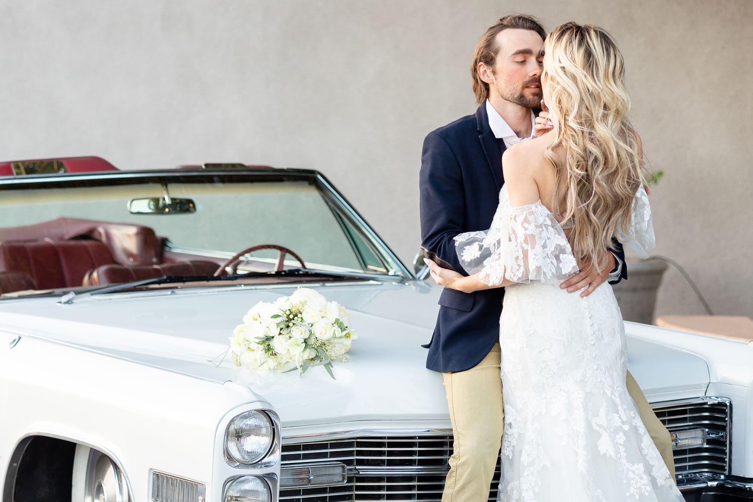 Romantic wedding photoshoot with classic white car in background.