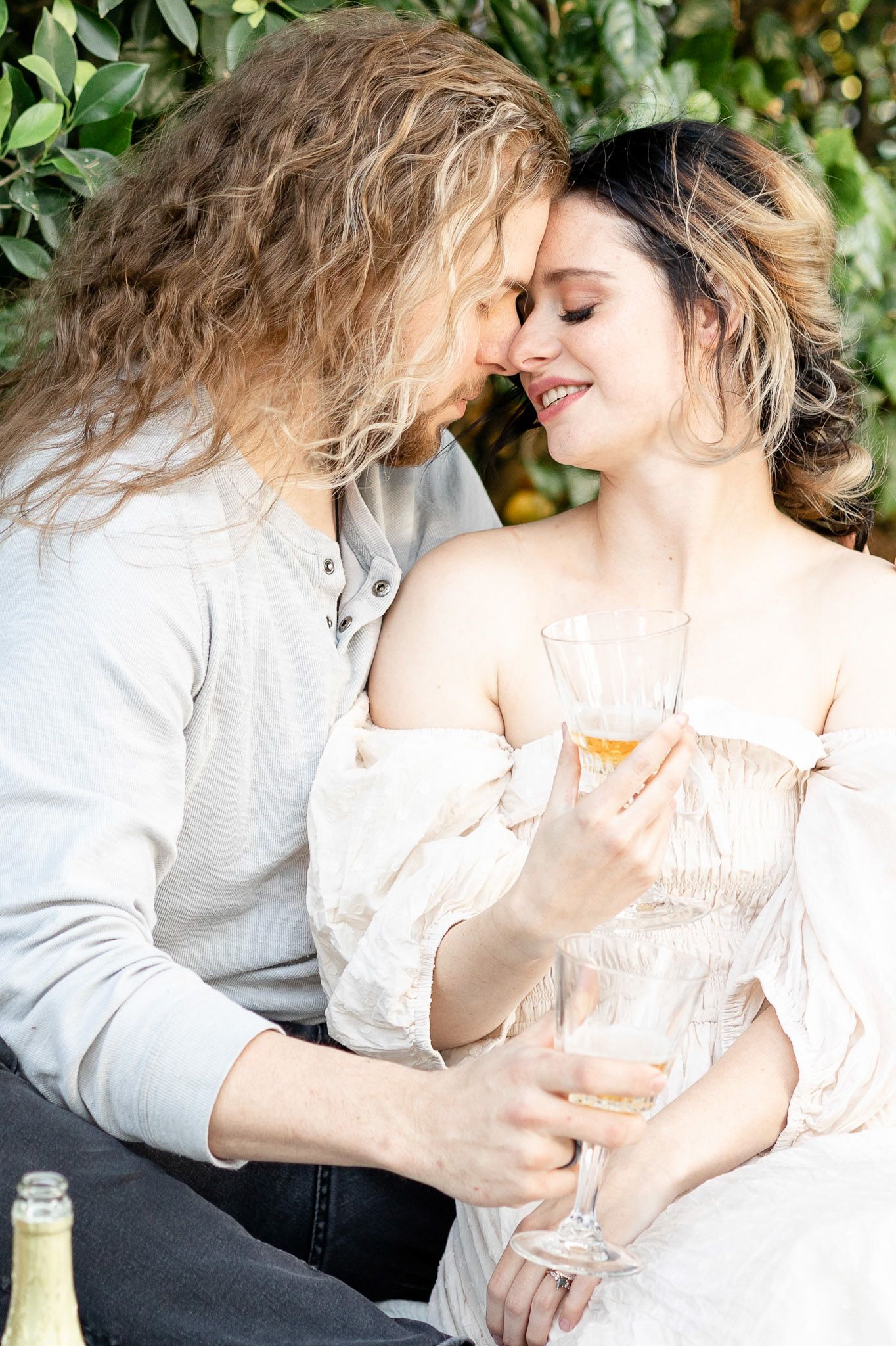 A romantic couple in light colored clothing embrace tenderly in a series of intimate photographs.