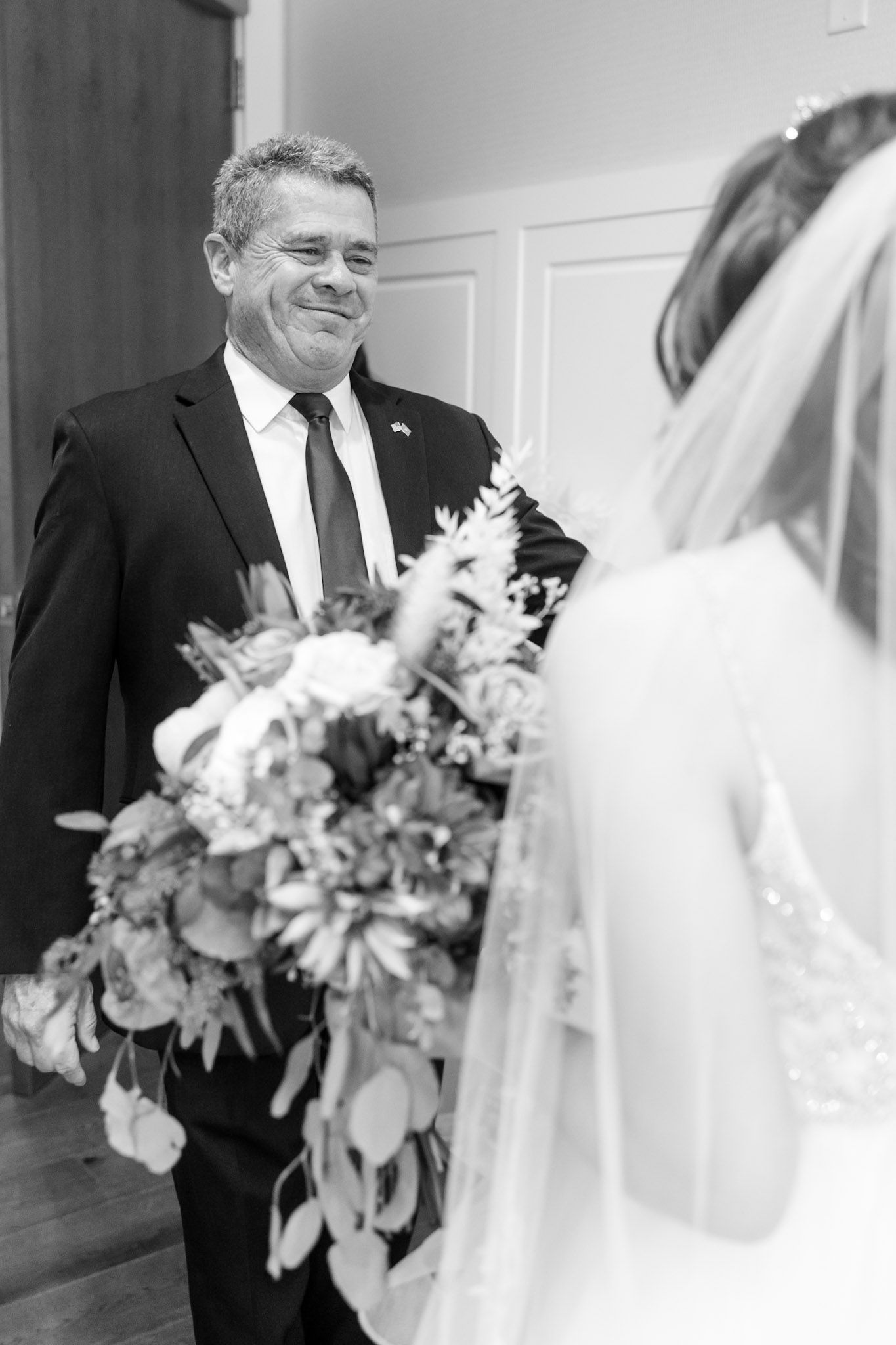 Black and white candid wedding moments with bride and suited figure.