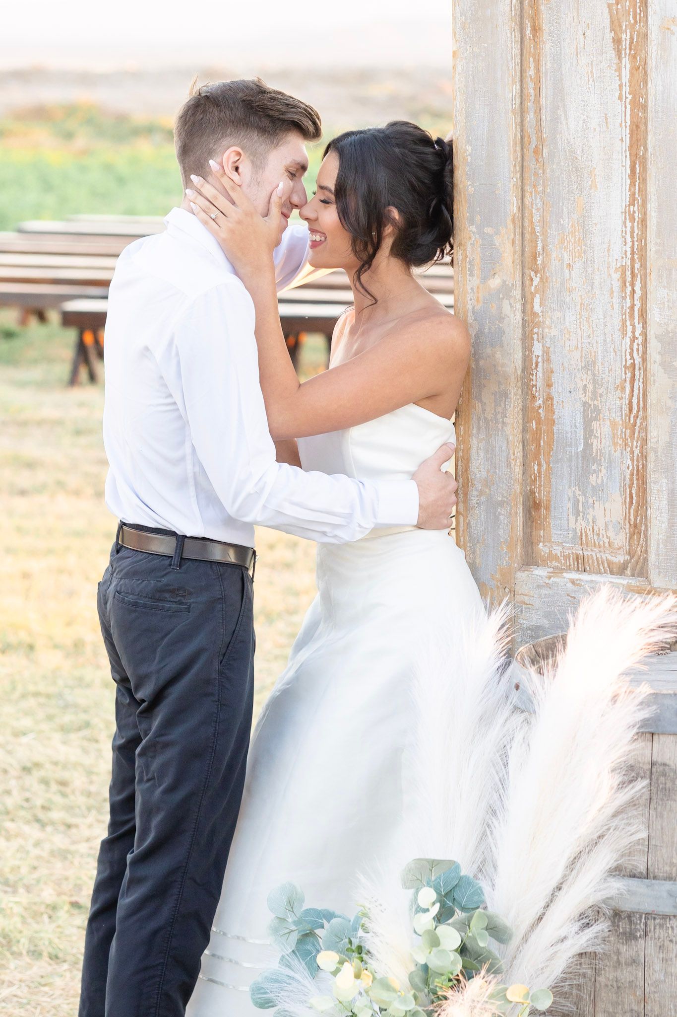 Tender wedding moments photographed by vintage wooden walls and countryside scenery.