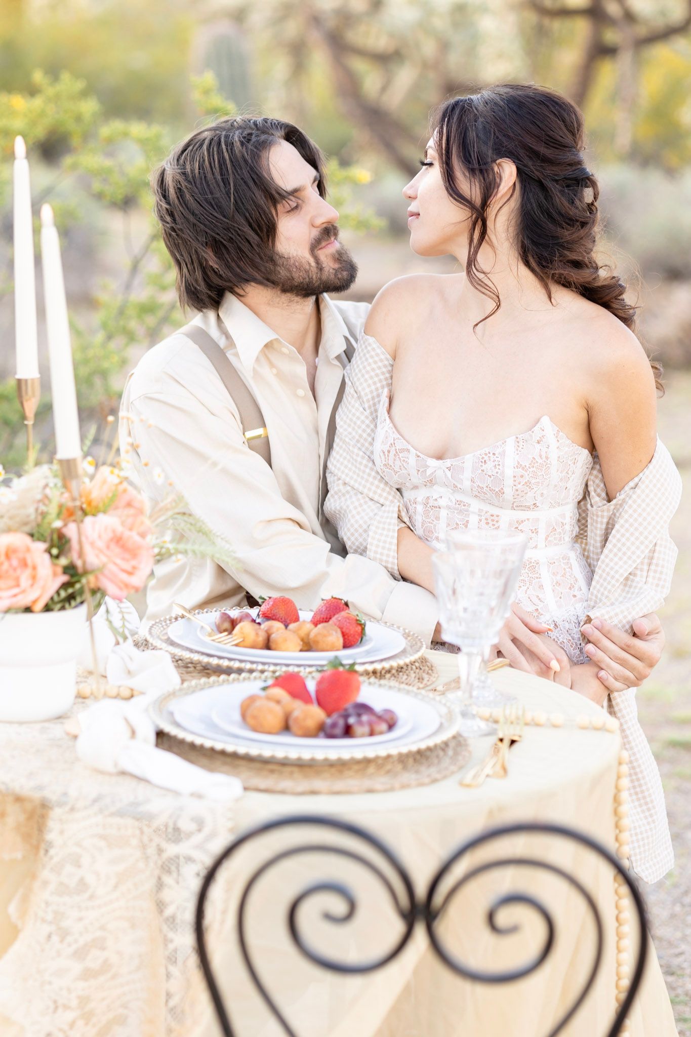 Vintage-inspired table setting with white candles, fresh fruit, and ornate metal details.