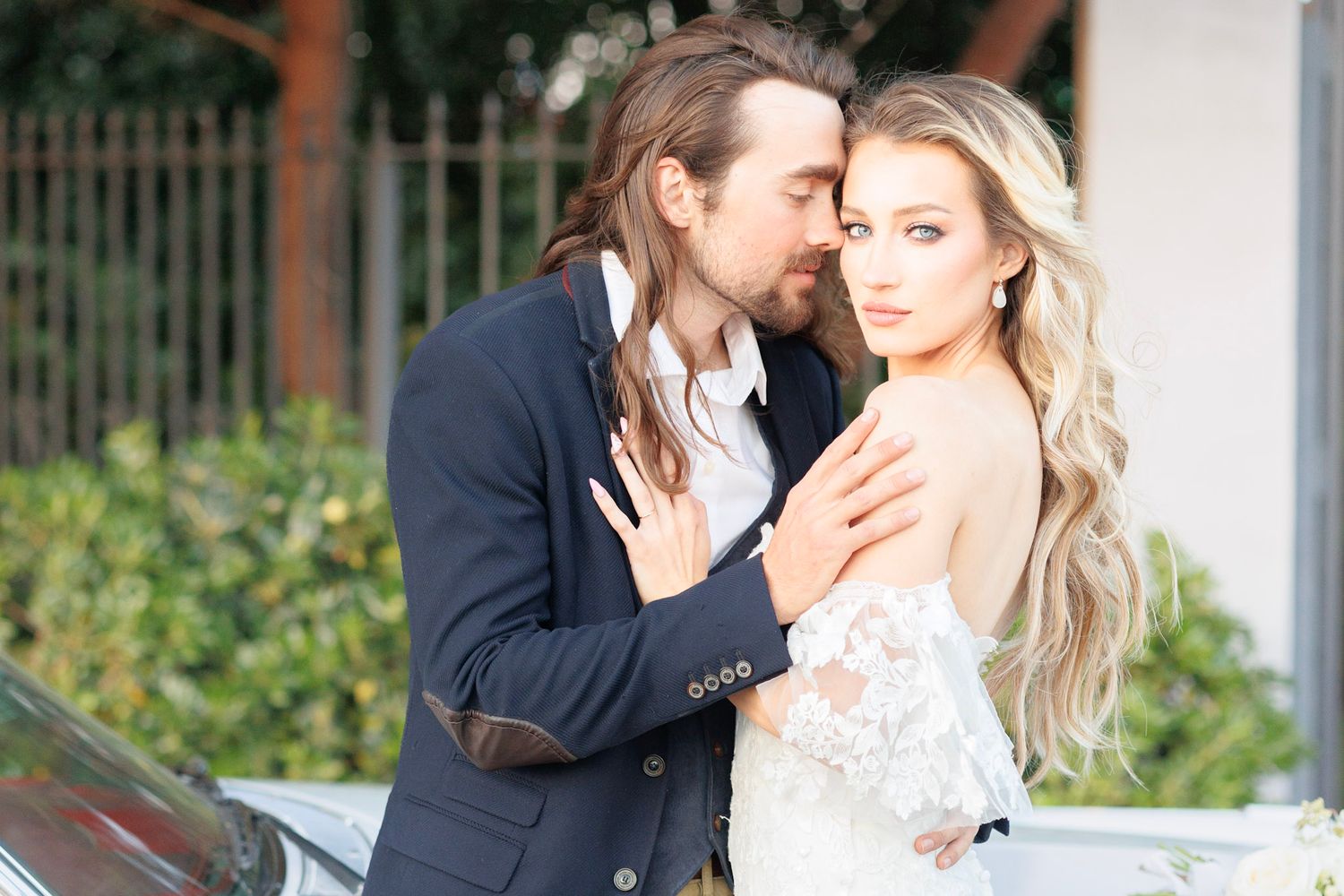 Romantic wedding portrait against neutral background with soft natural lighting.