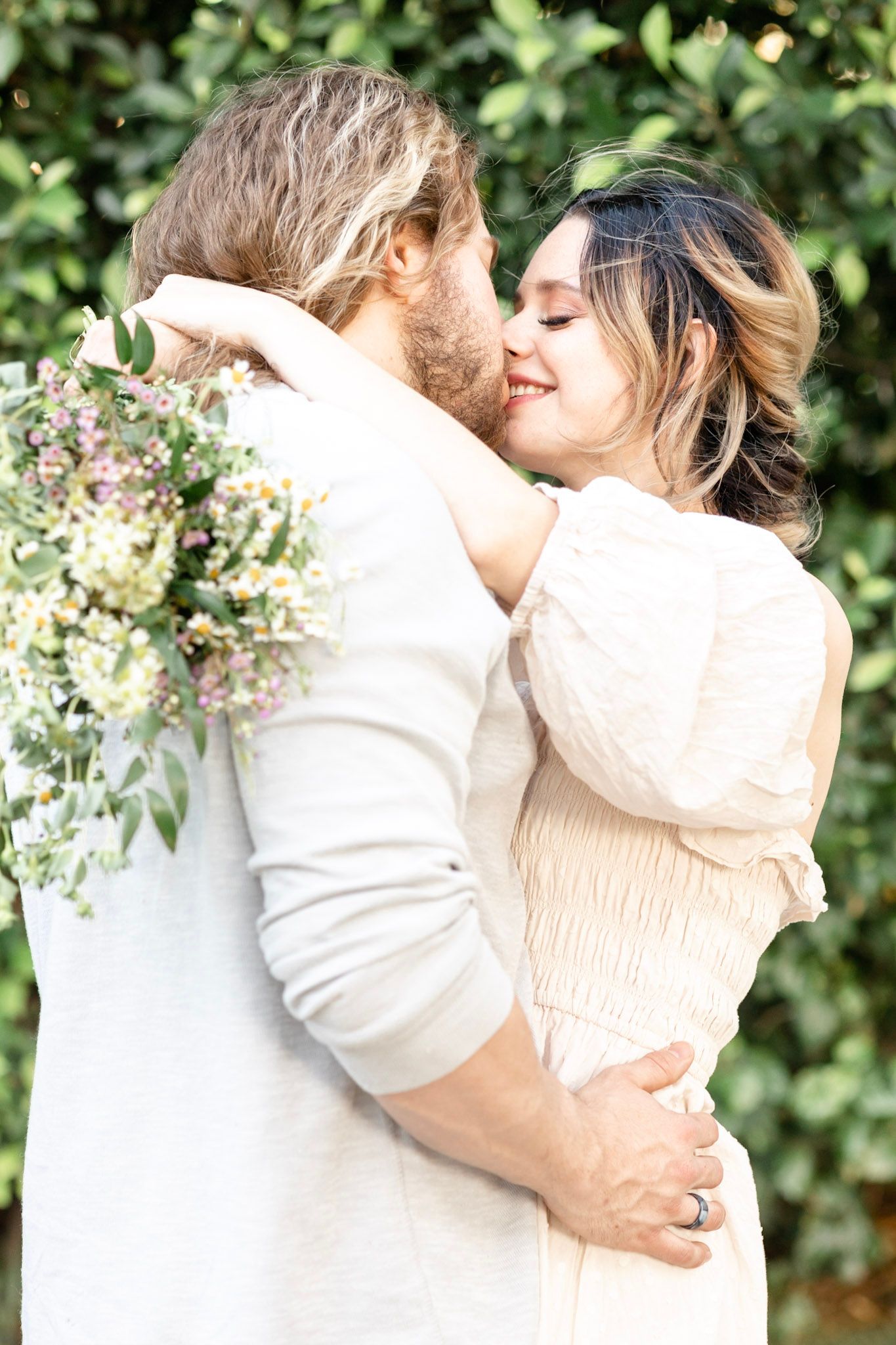 Romantic outdoor embrace against lush garden backdrop with vintage-inspired styling.