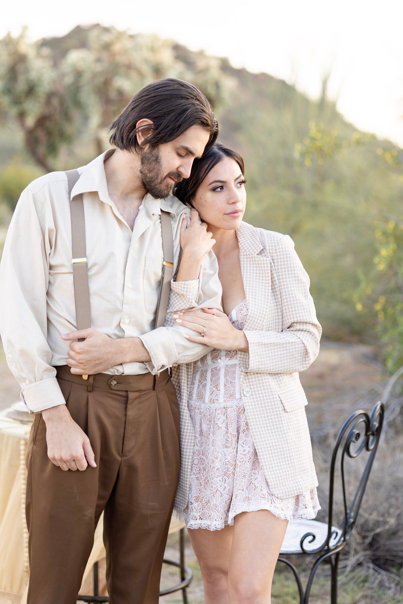 Intimate outdoor portrait session with couple in vintage-style clothing against natural backdrop.