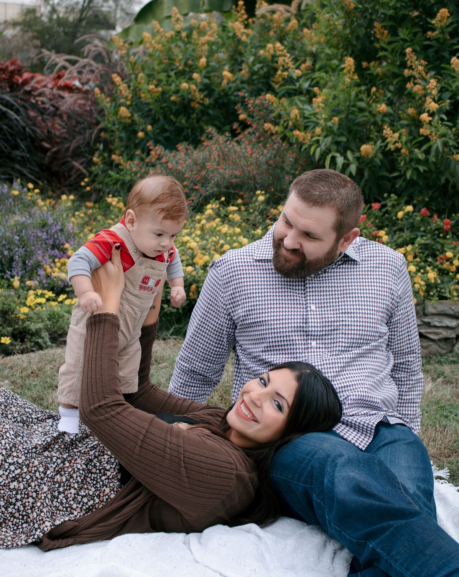 Family sharing joyful moments together on blanket outdoors.