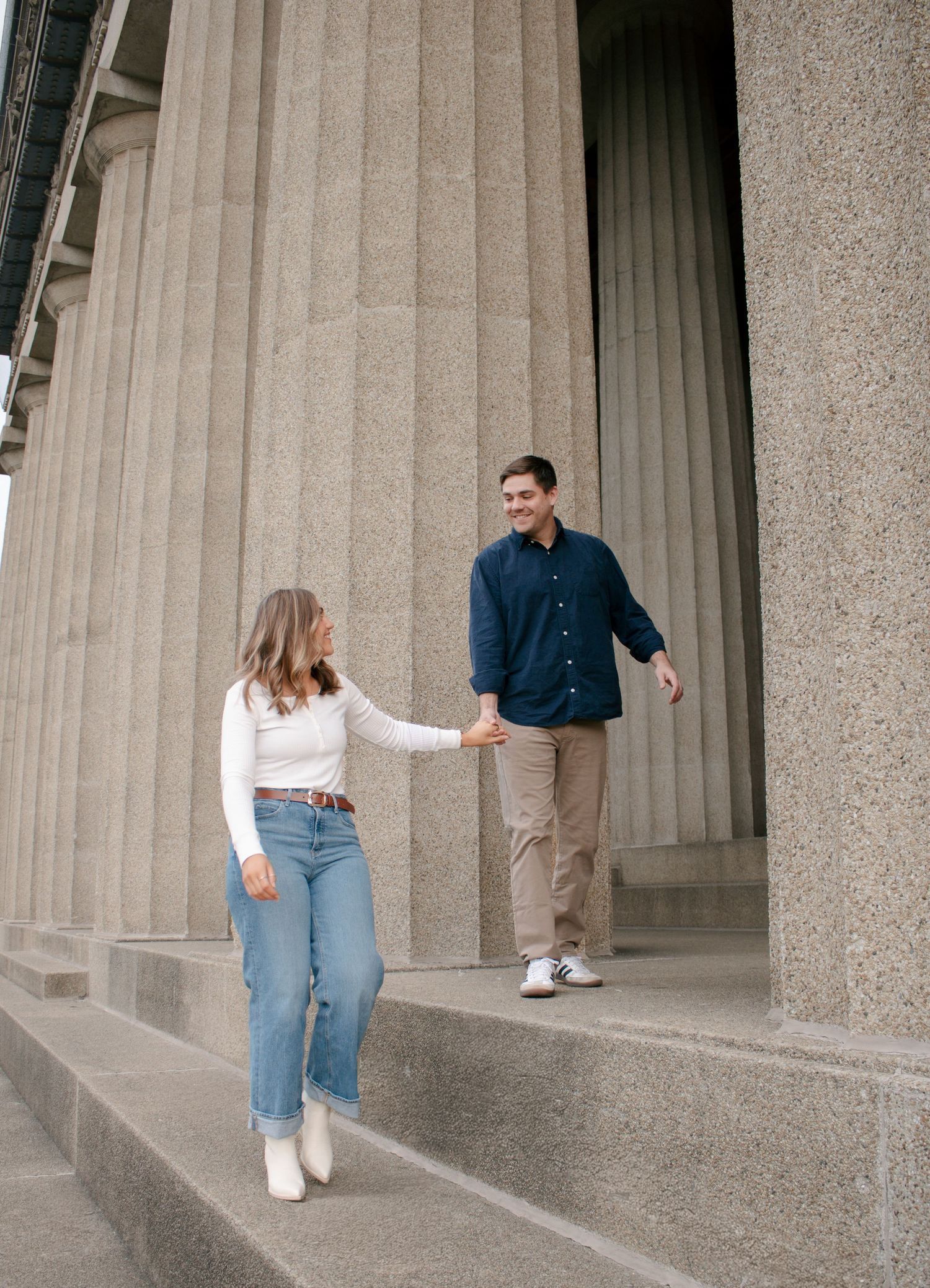 Four sequential images show a couple walking between stone columns in a classical architectural setting.