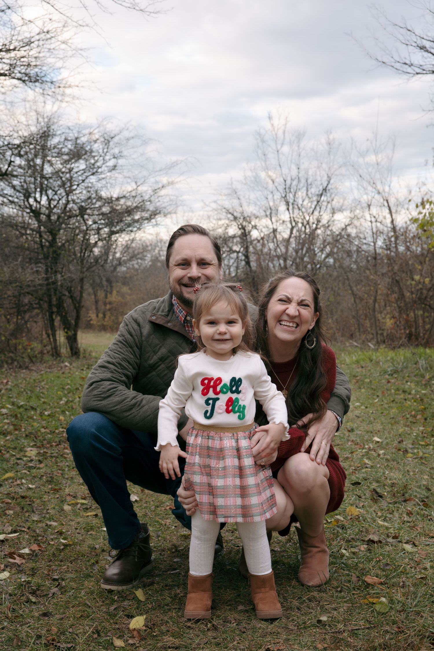 A series of outdoor family photos taken in a natural setting with bare trees and grass in the background.