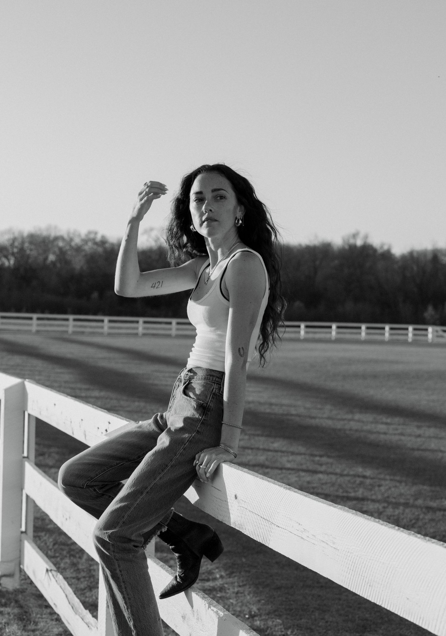 Black and white artistic photo series showing someone posing on a white fence in casual summer attire.