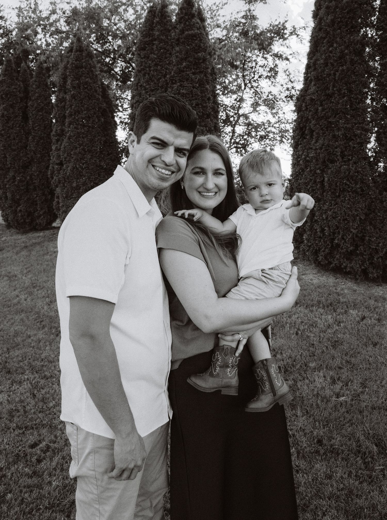 Family embraces for black and white portrait outdoors.