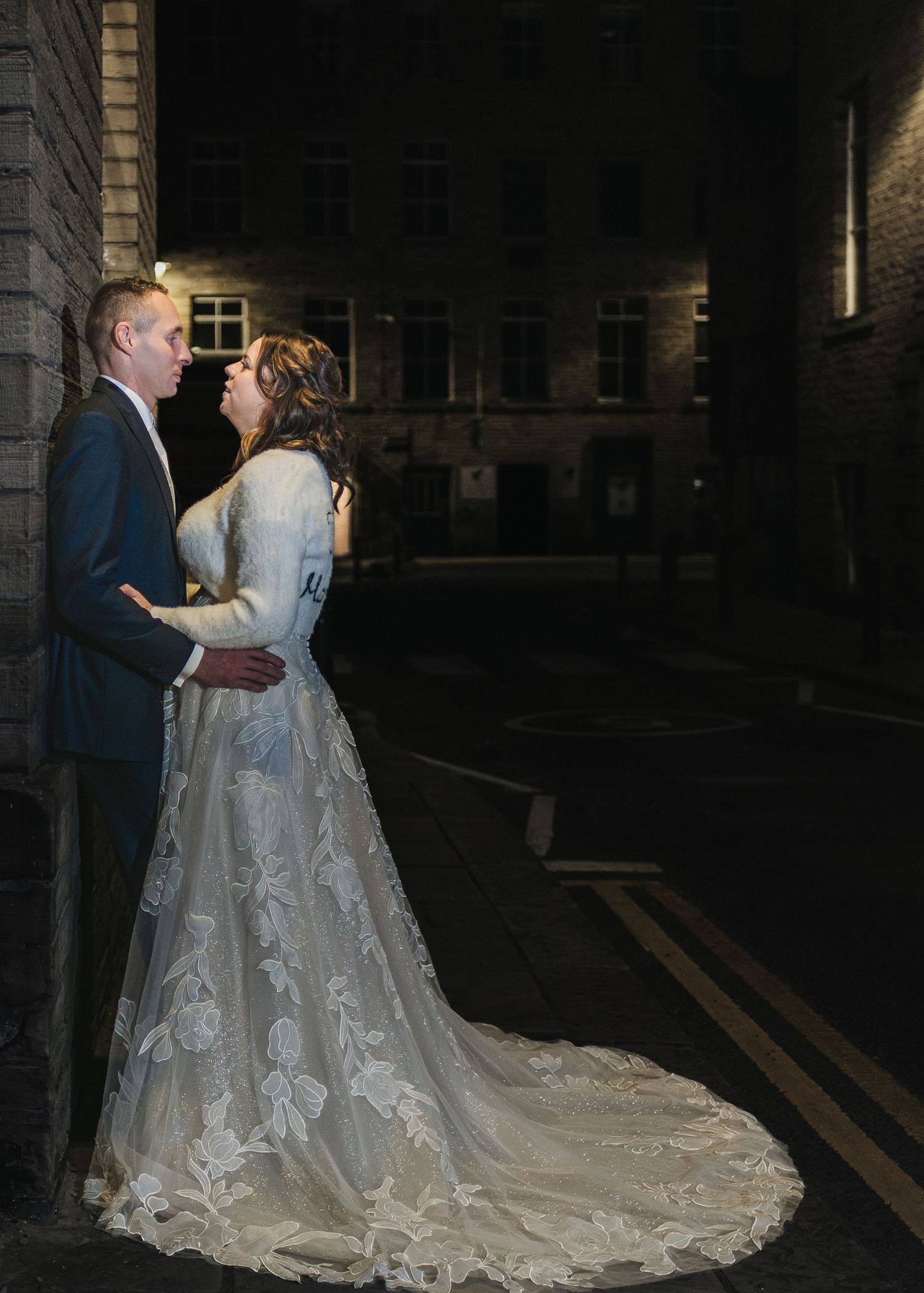 Dramatic nighttime wedding portraits showcasing a bride's long lace train. Ephemera.