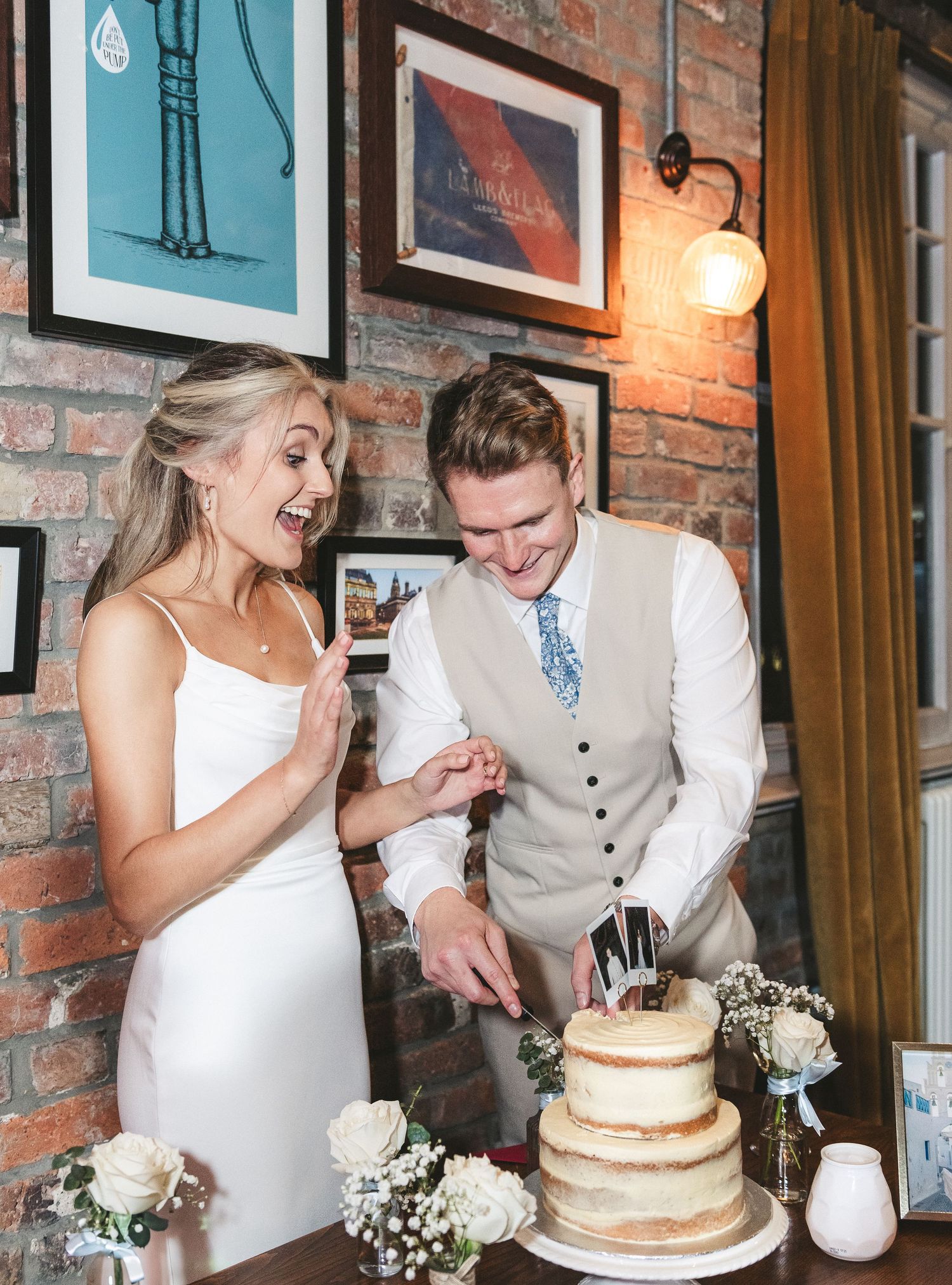Newlyweds sharing a joyful moment while cutting their rustic wedding cake. Ephemera.
