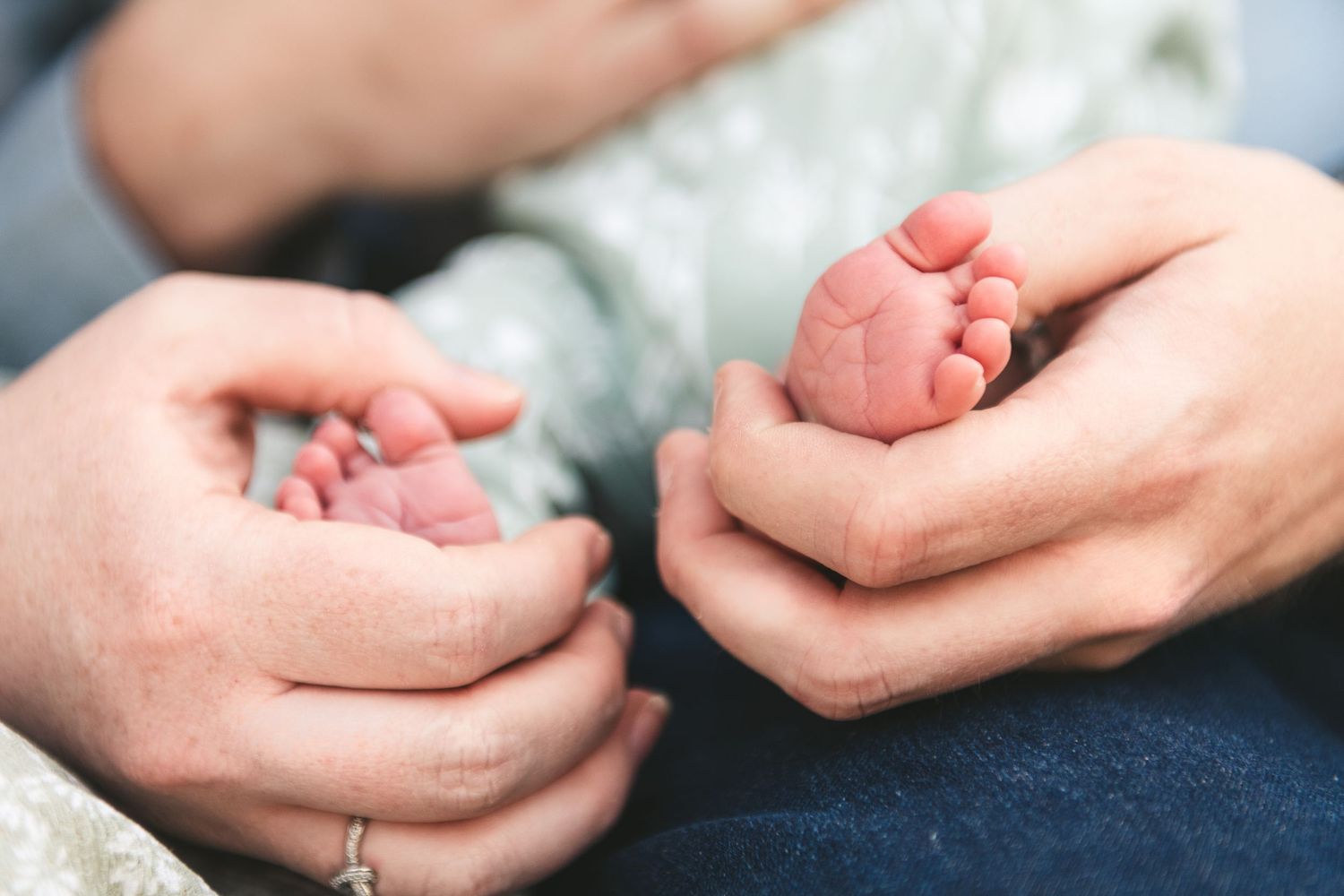 Tiny newborn baby feet held gently in parent's hands. Ephemera.