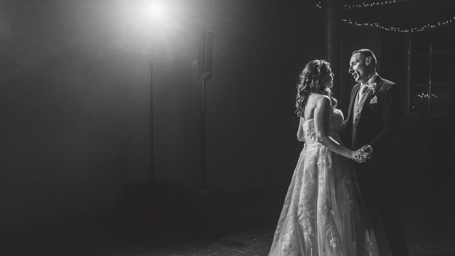 Romantic wedding dance captured under twinkling lights in black and white photography. Ephemera.