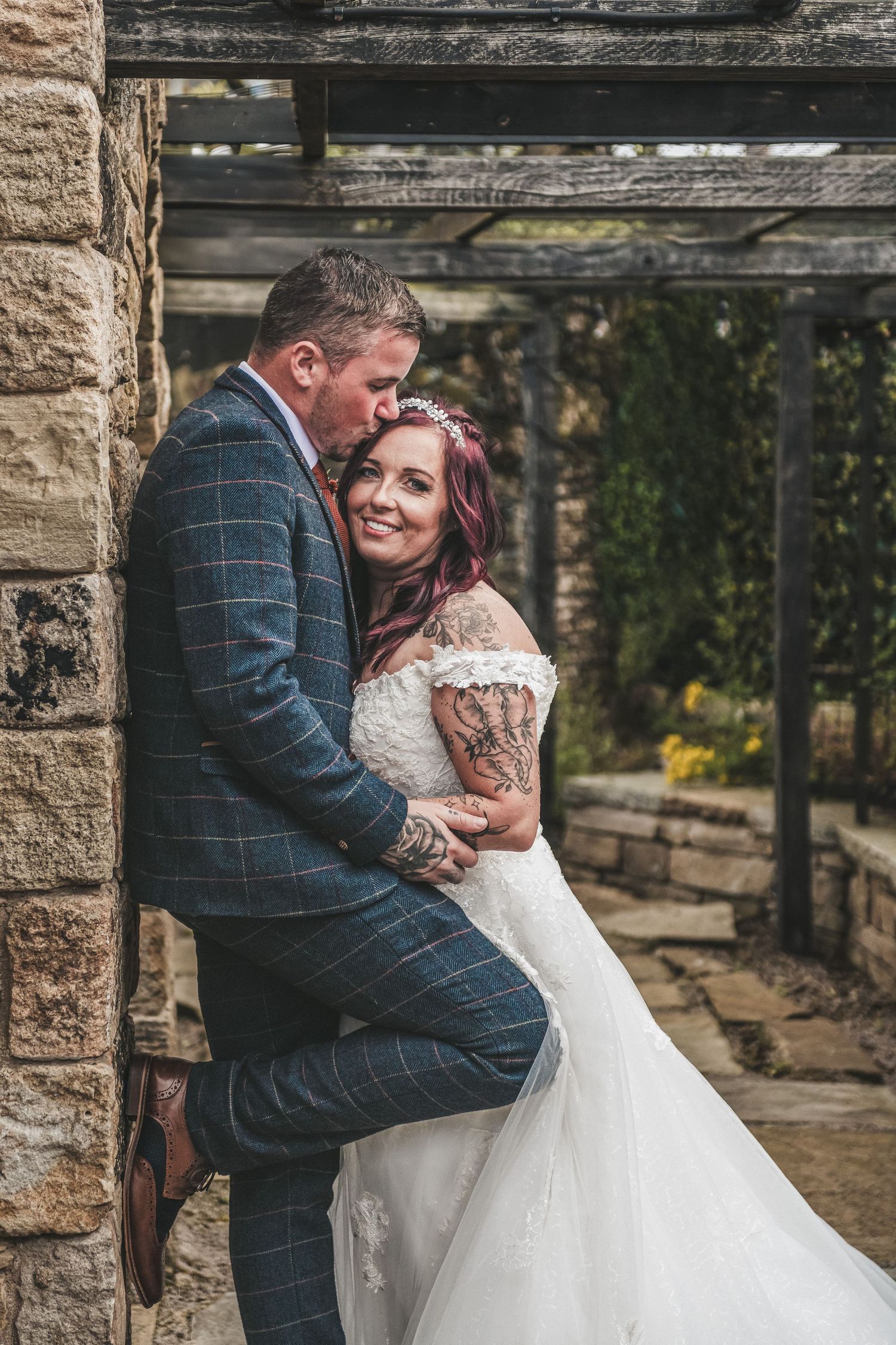 Newlyweds sharing intimate moment against stone wall backdrop. Ephemera.