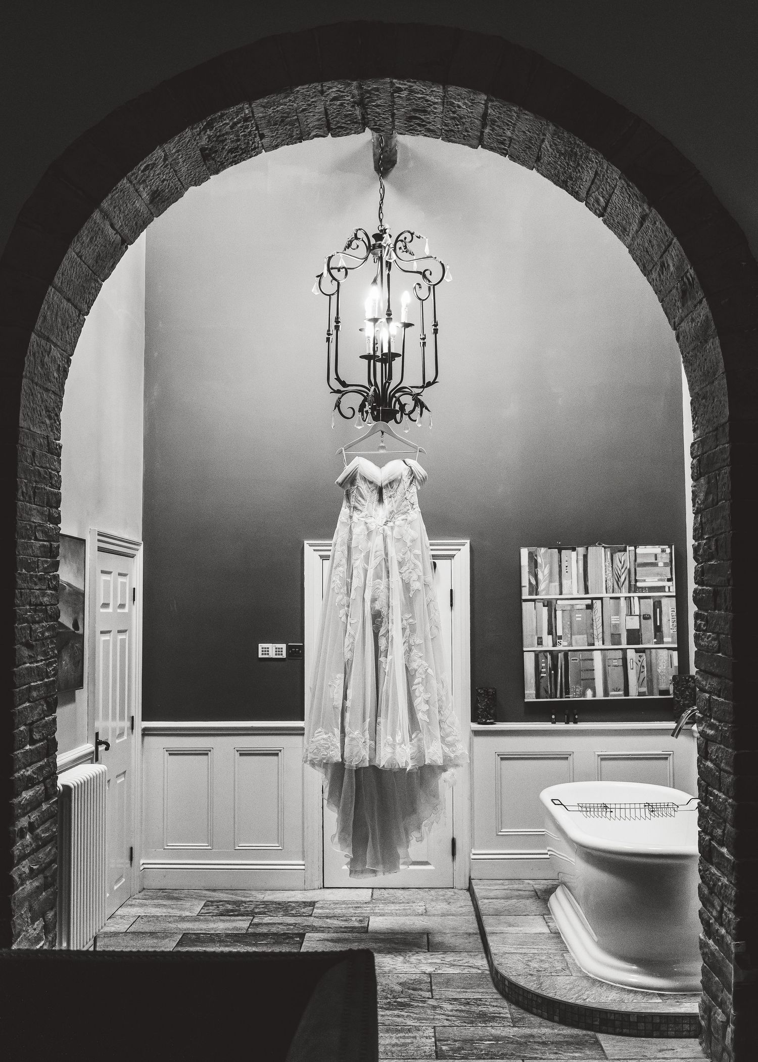 Wedding dress and accessories displayed in arched alcoves with elegant lighting. Ephemera.