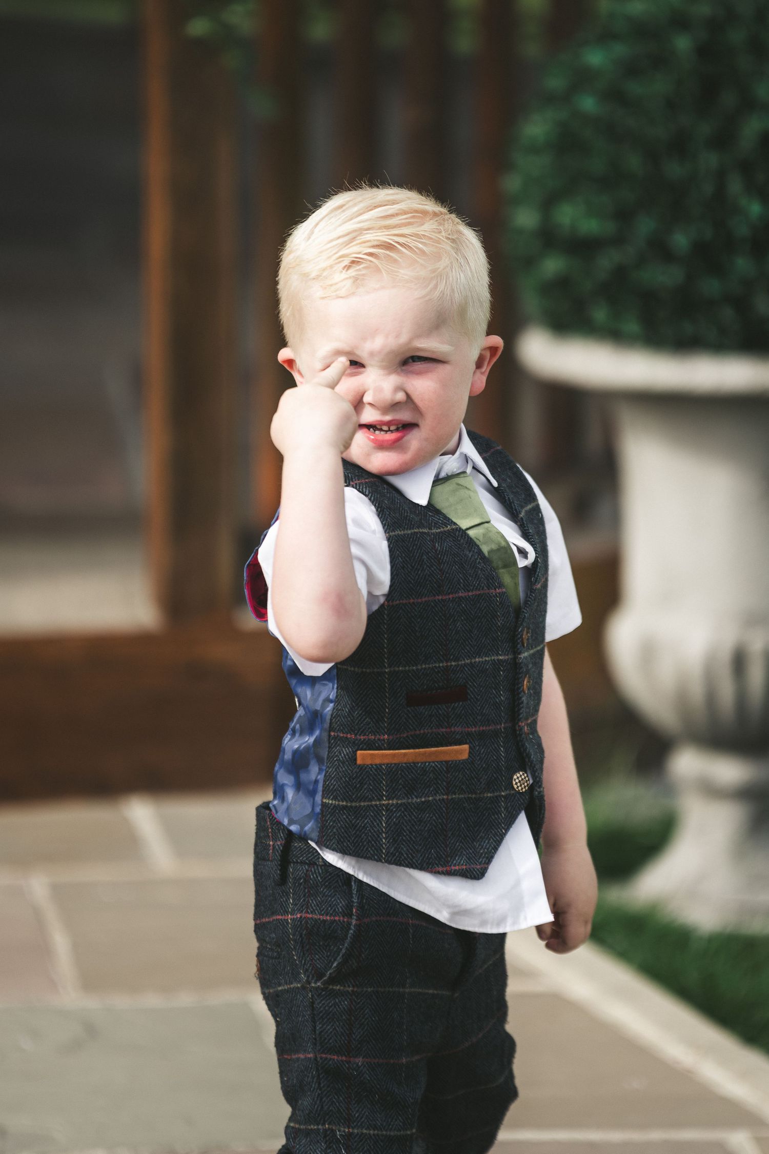 Young boy in formal vest and tie making a silly face expression. Ephemera.