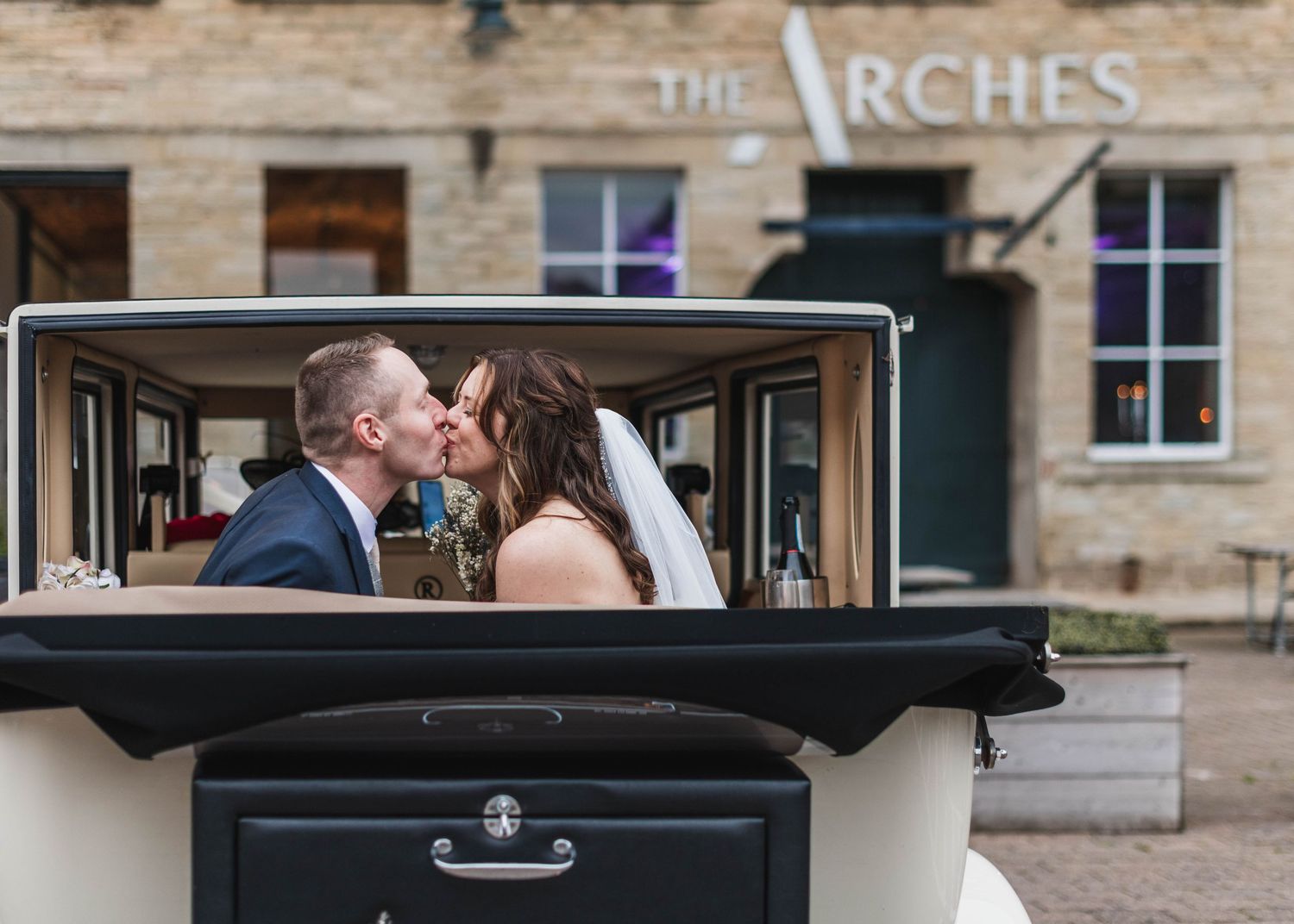 Romantic moment captured between two people in formal attire at The Arches venue. Ephemera.
