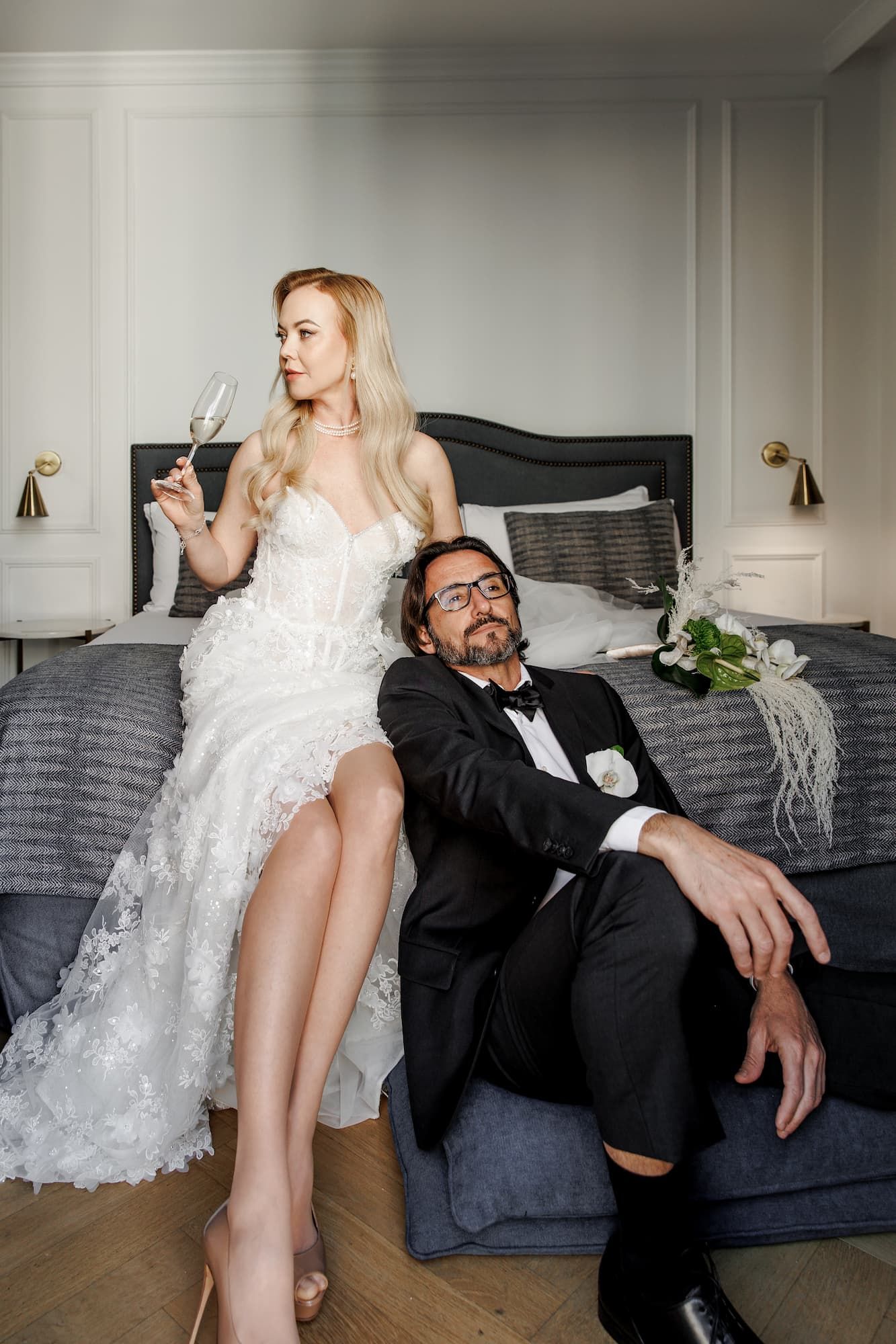 A couple in wedding attire playfully interacts on a gray couch in a sequence of candid moments.