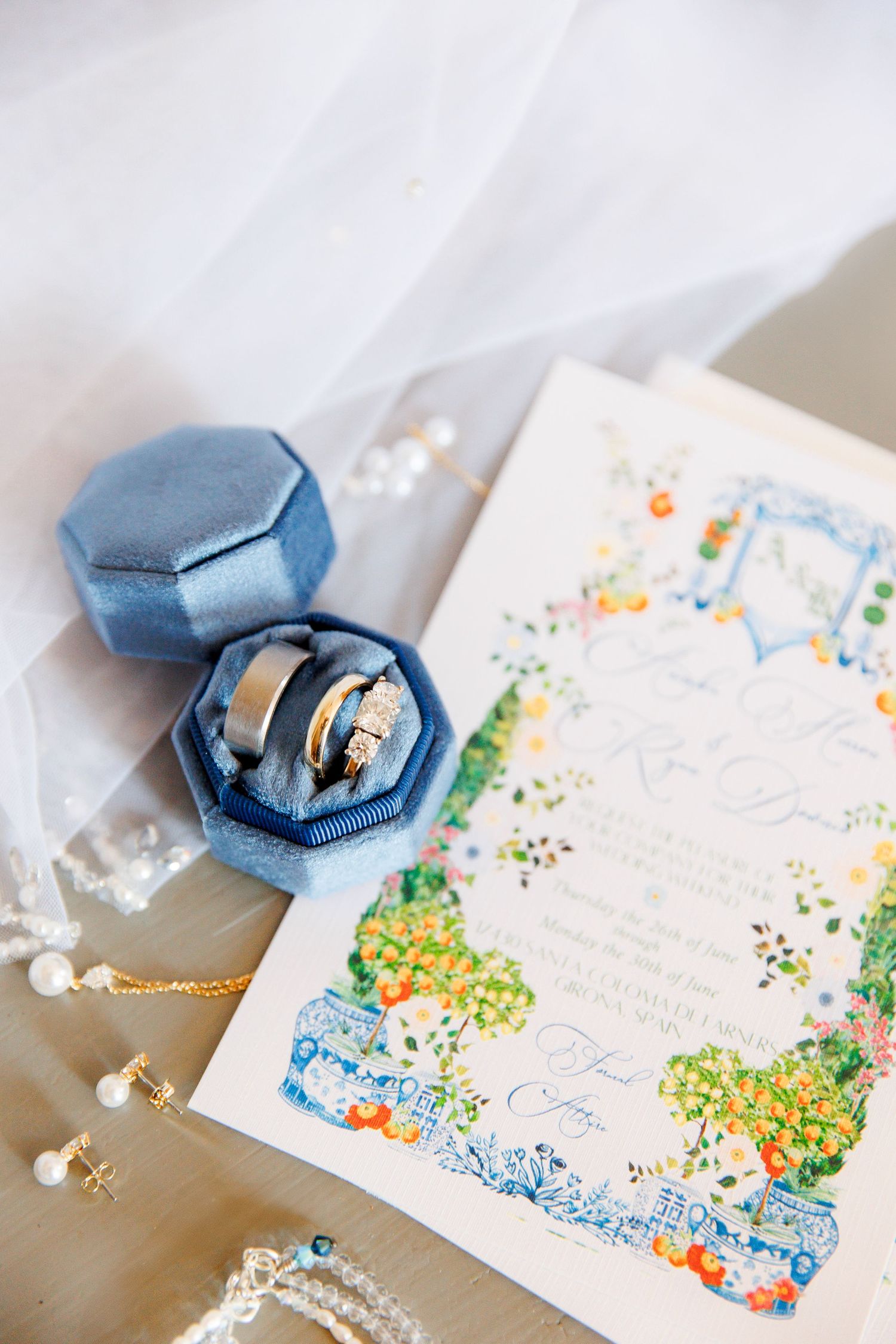 Wedding stationery with watercolor floral designs and blue velvet ring box.