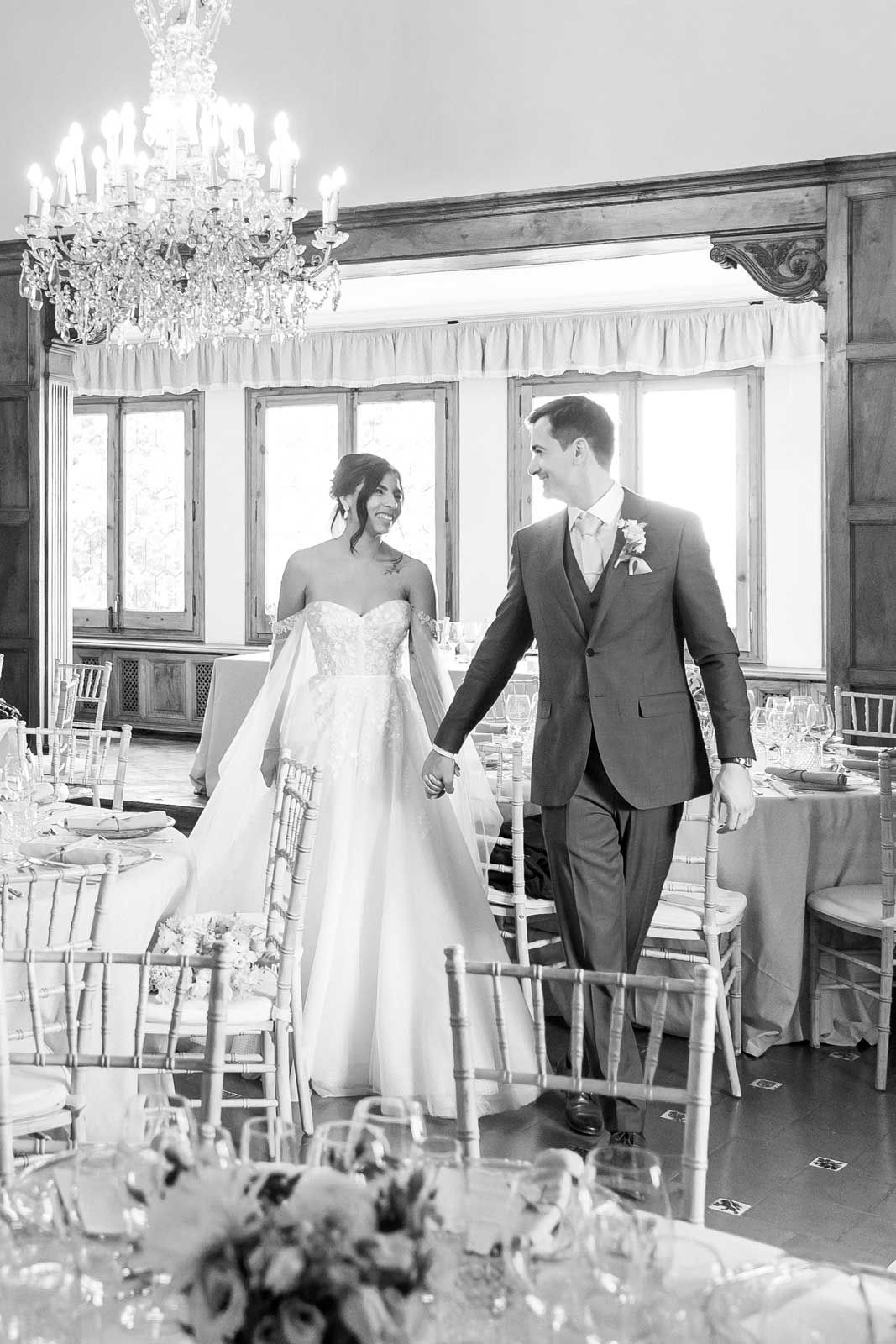 The groom is pulling the bride through the decorated area for the wedding dinner at La Baronia wedding venue
