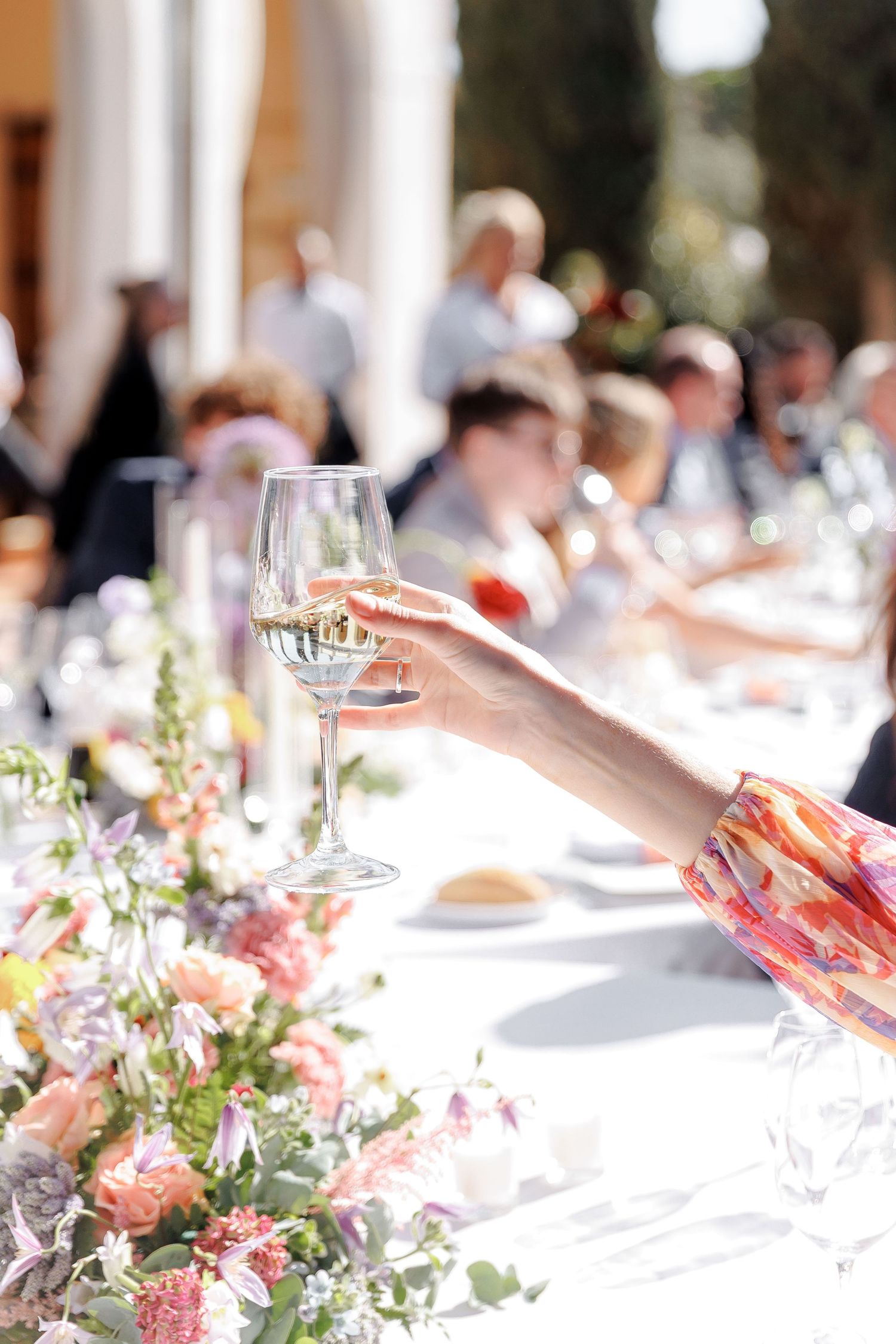 A photo of a hand with a glass of cava at the wedding reception