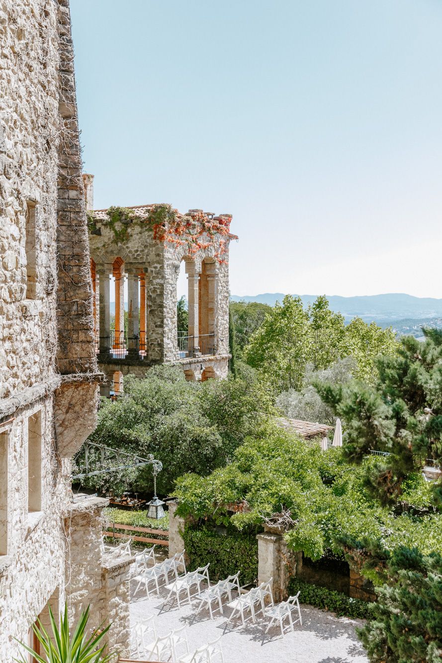 Ancient stone ruins with white chairs set for an outdoor wedding ceremony, La Baronia