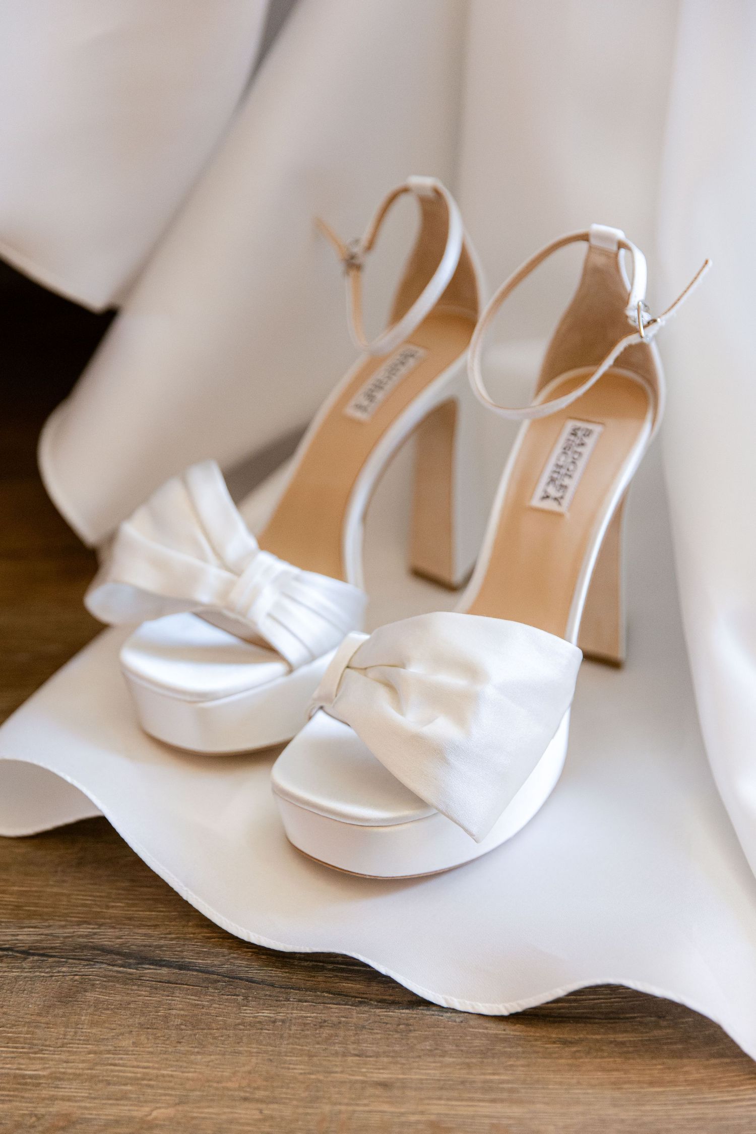 White wedding shoes next to the hanged dress
