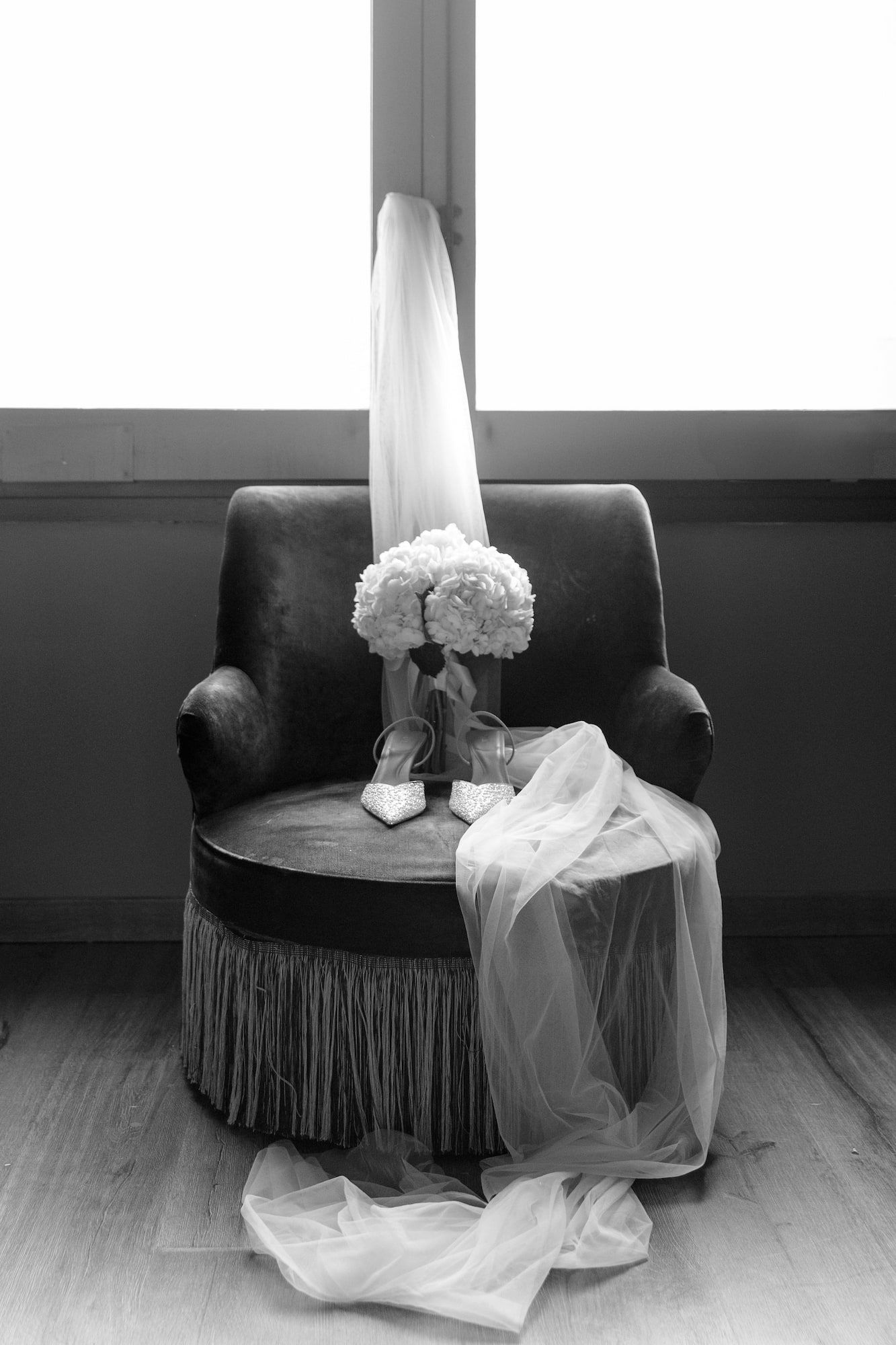 Close up shoot of a bridal veil, shoes and flowers in black and white.