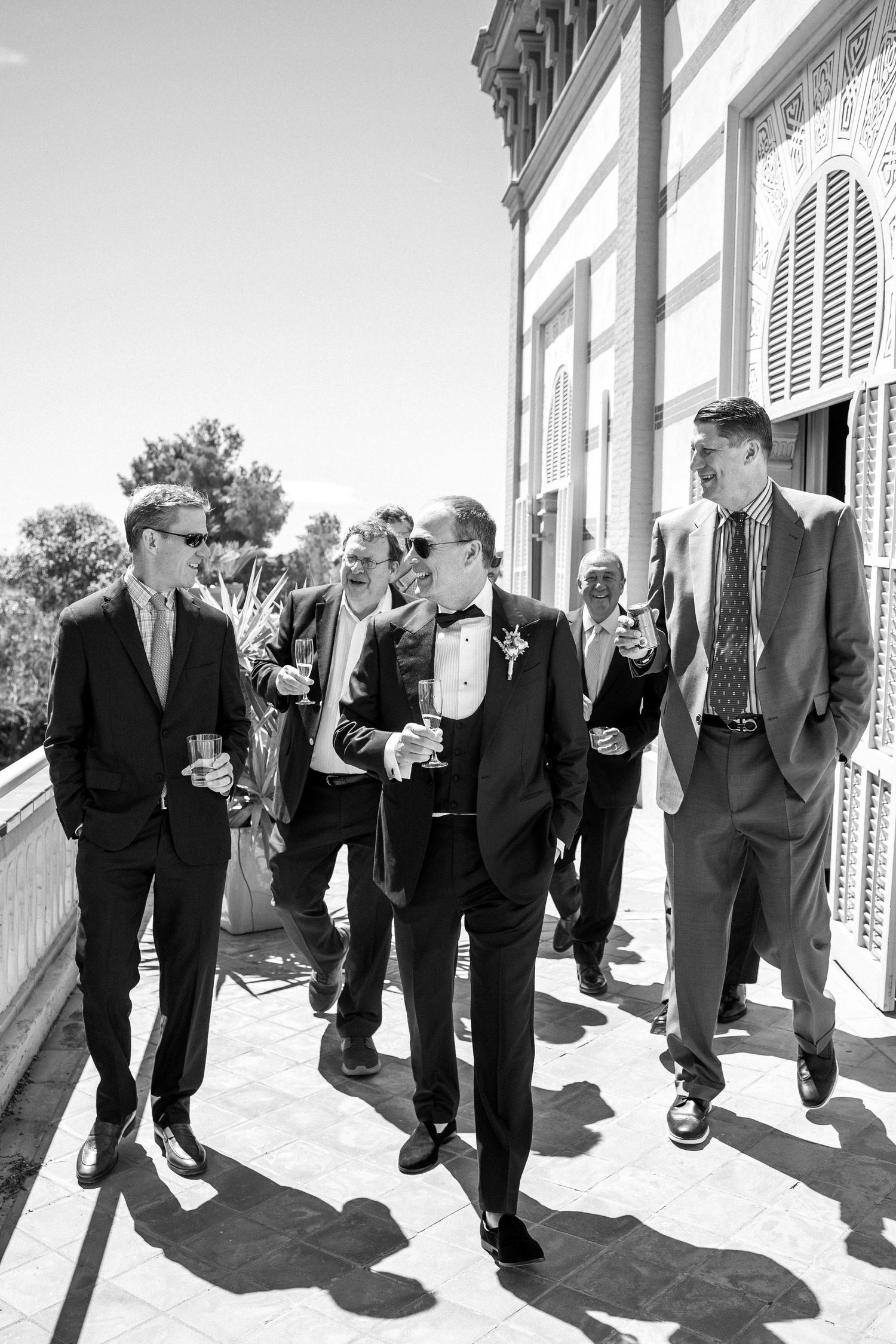 The groom and his bestmen at the balcony of the wedding venue in Barcelona