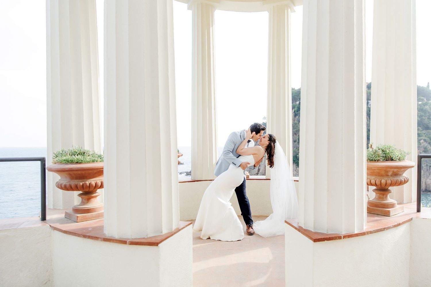 A newly married couple kisses following their wedding ceremony in Costa Brava, Spain.