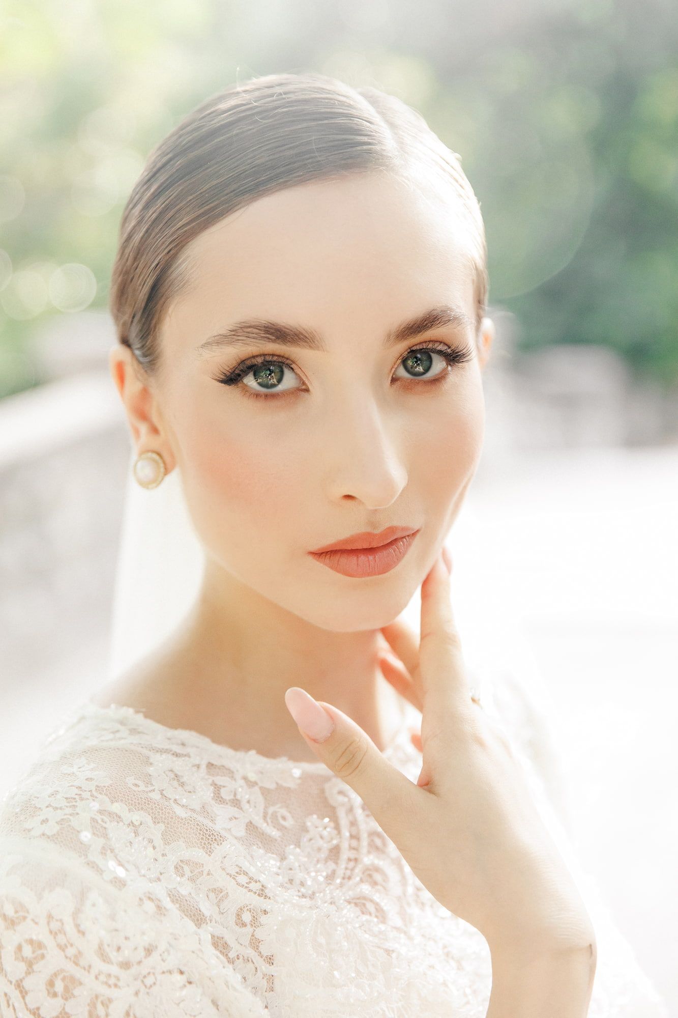 Close up portrait of someone wearing delicate white lace in soft natural lighting with glowing makeup.