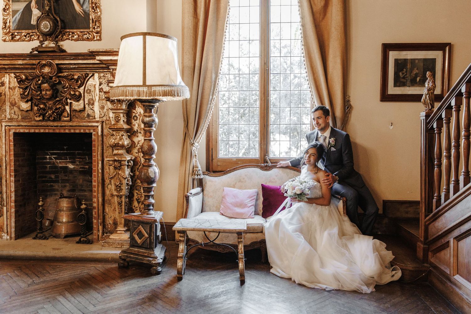 The newlyweds are sitting on the elegant sofa of a traditional wedding venue La Baronia