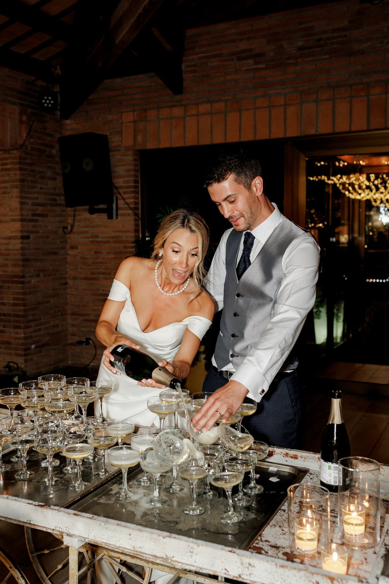 Newlyweds celebrate the dinner by opening a champagne bottle.