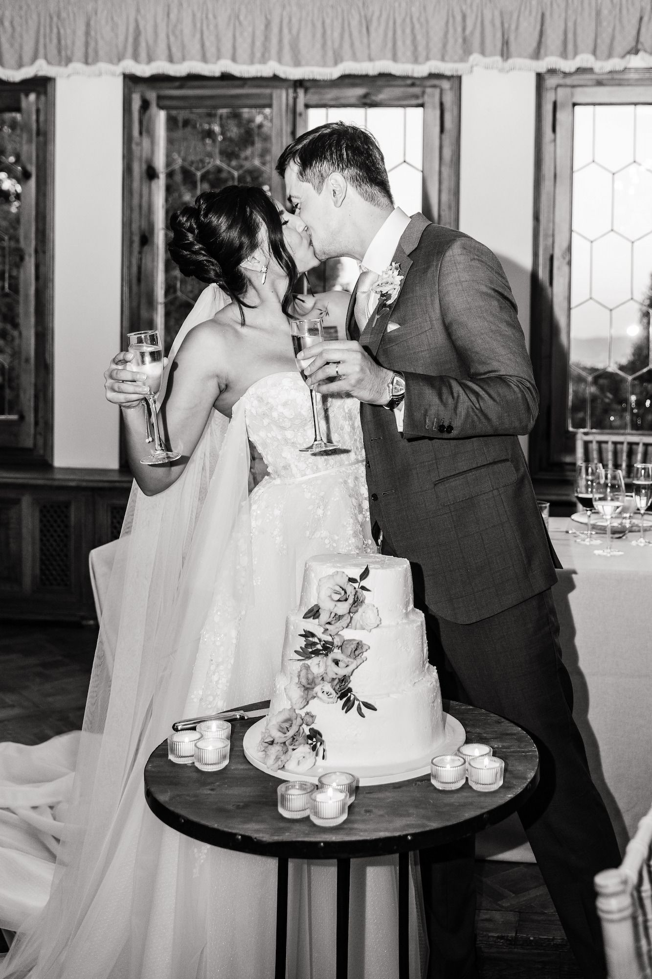 The bride and groom share a kiss after cutting the wedding cake.