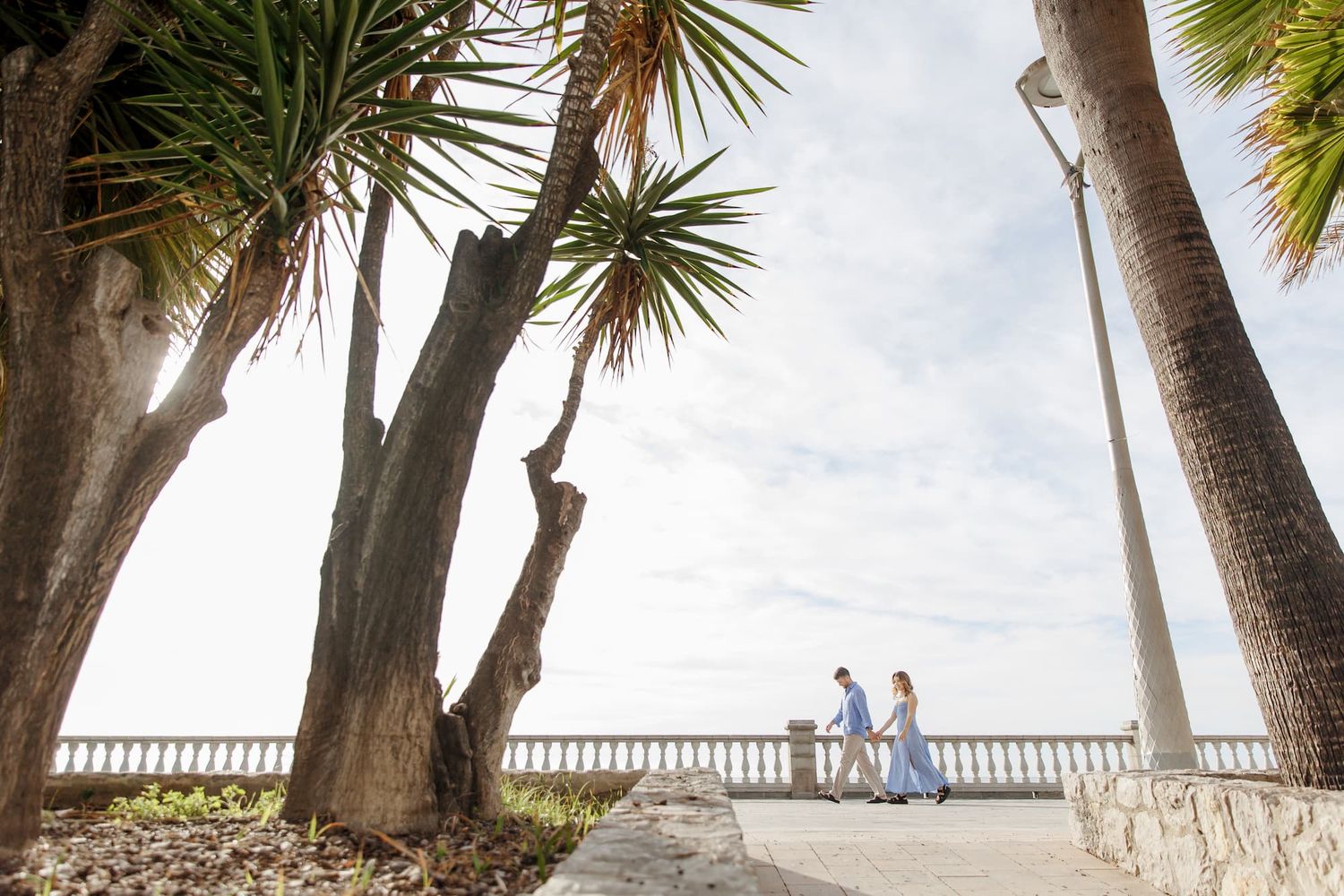 A man pulling a girl over the coastline during their engagement session in Barcelona