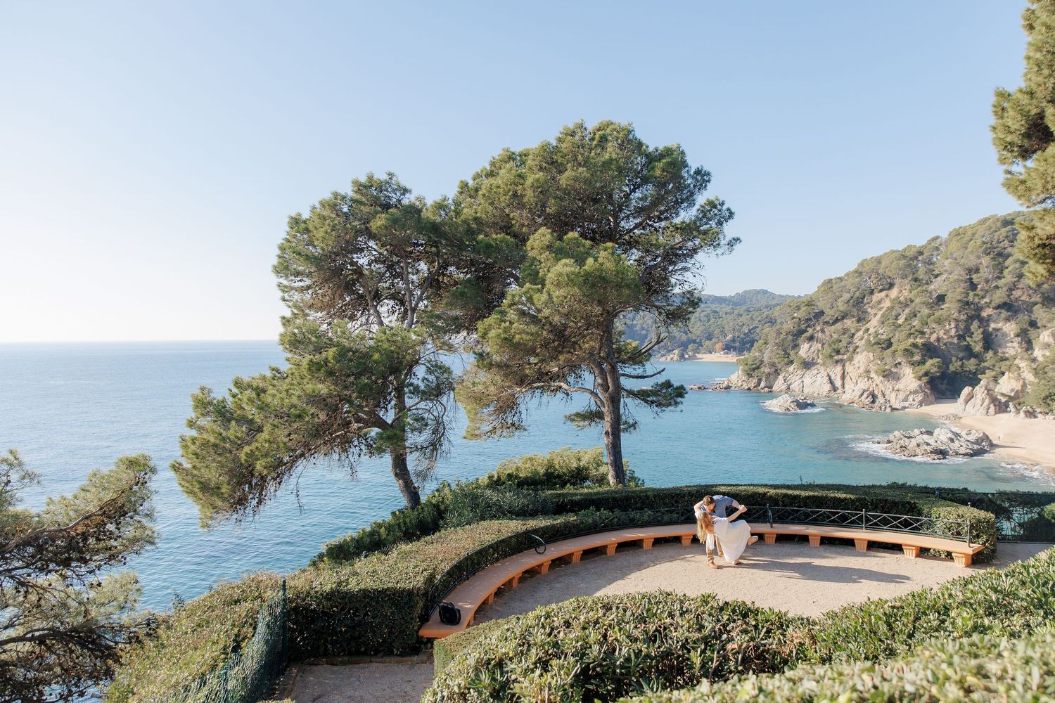 The engaged couple dances in the park, admiring the blue waters of the Mediterranean Sea.