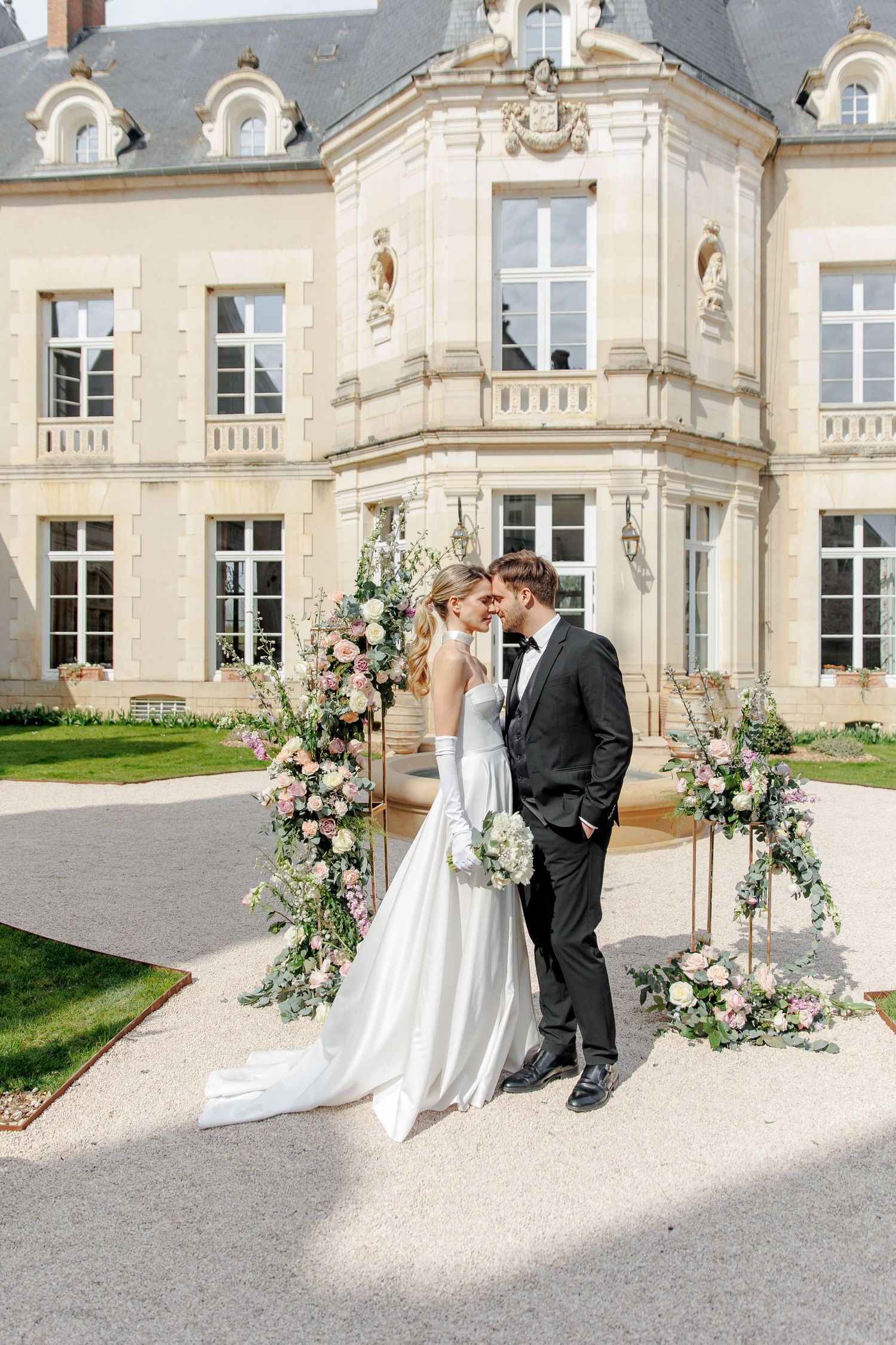 Classic wedding portrait of the bride and groom in front of the French chateau
