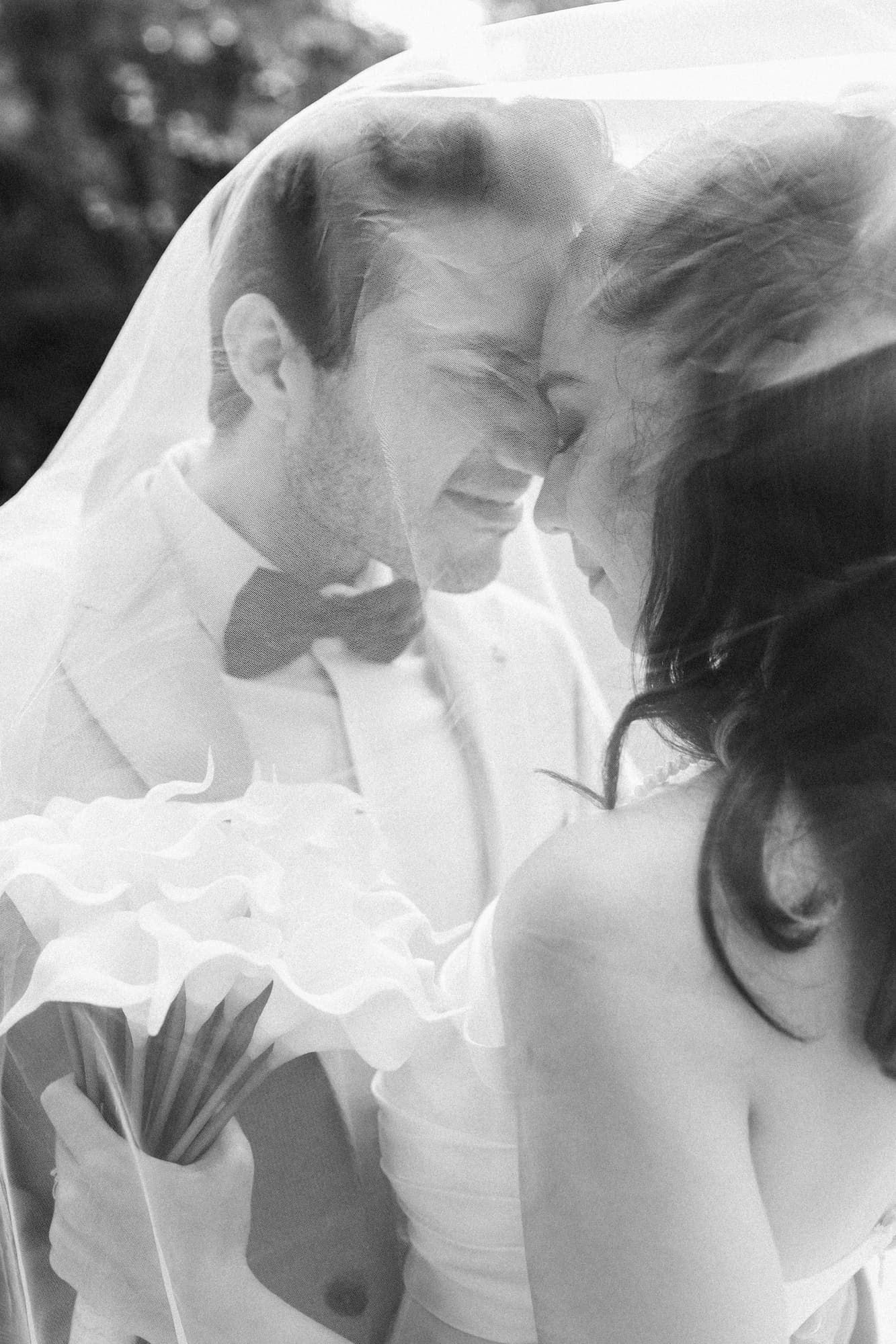 A romantic black and white wedding photo series showing tender moments between a couple in traditional wedding attire.