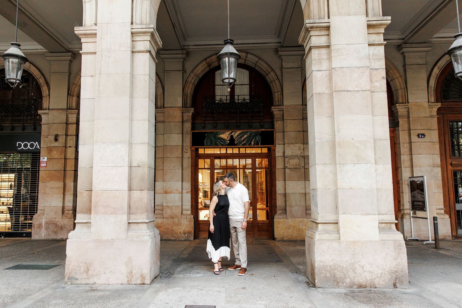 An engaged couple kisses next to the iconic architecture of the El Born area, Barcelona