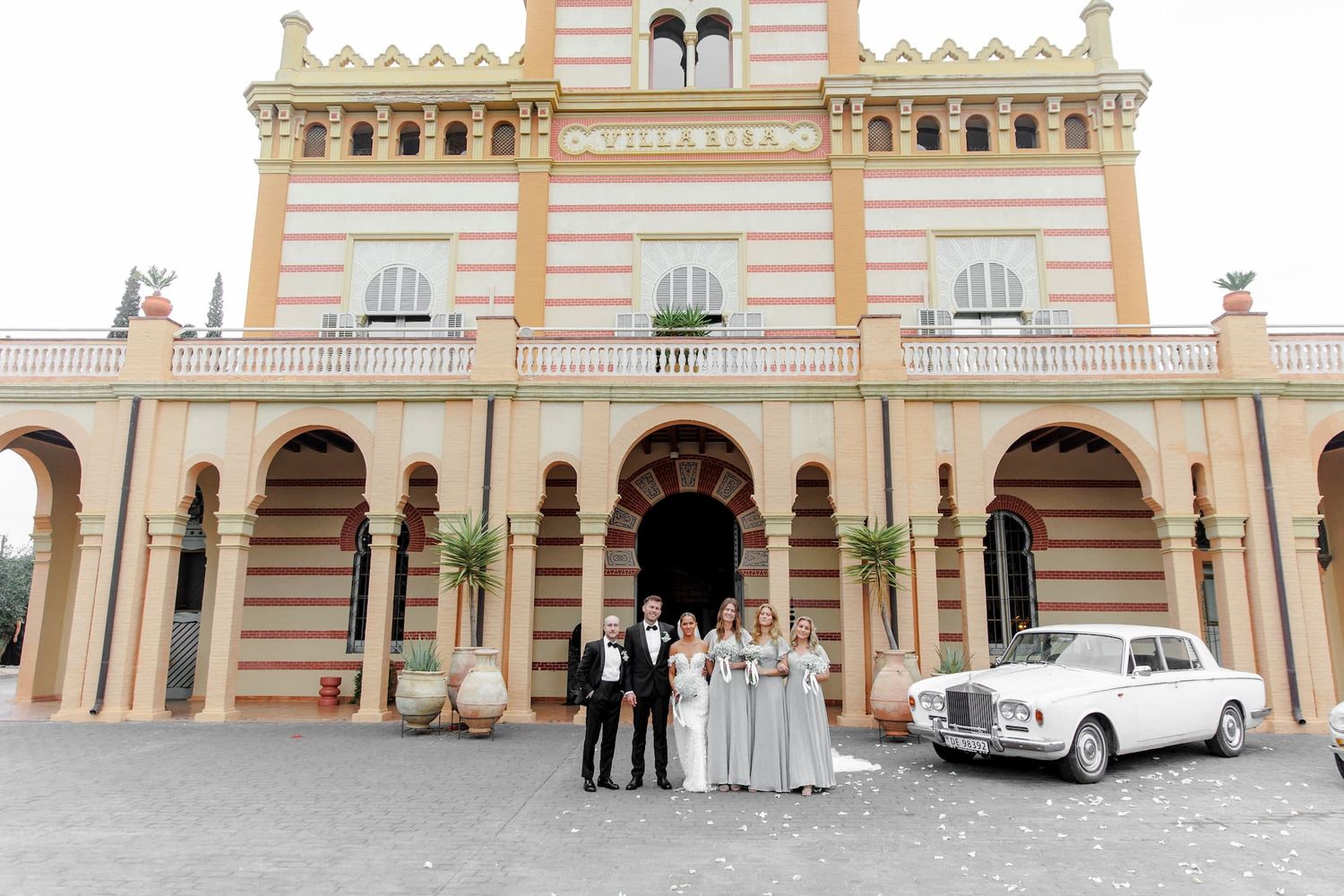 Wedding party poses with vintage white Rolls-Royce at Gran Villa Rosa, Barcelona