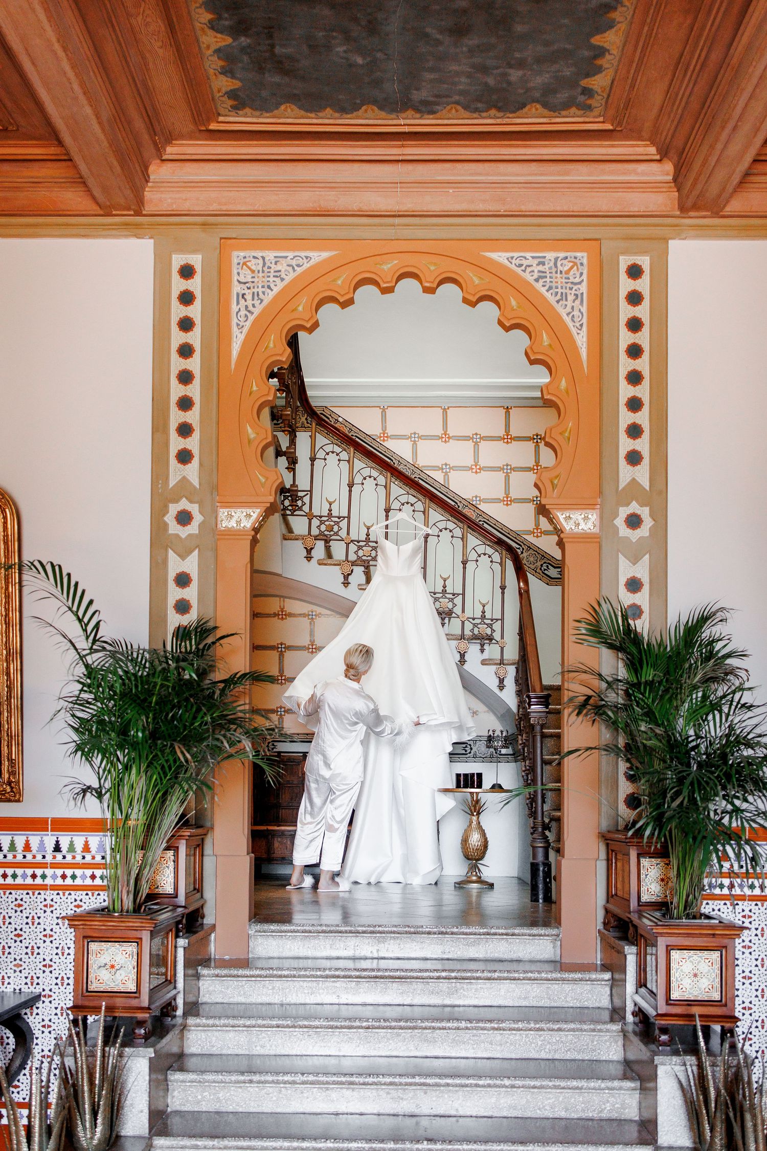 The photo of the bride going down the stairs to check her dress