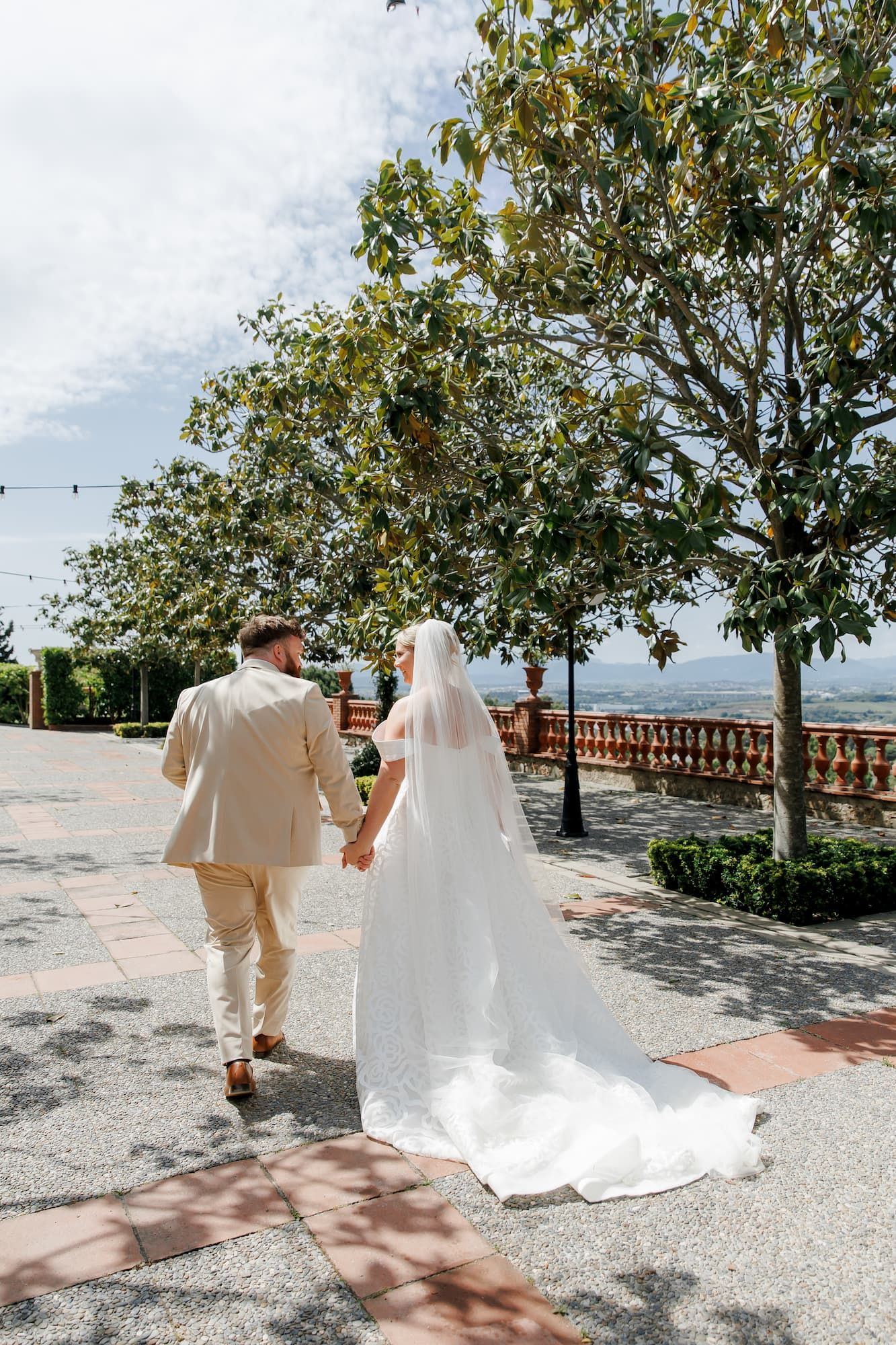 The bride and groom walking hand in hand through the Mas de Sant Lleí wedding venue.