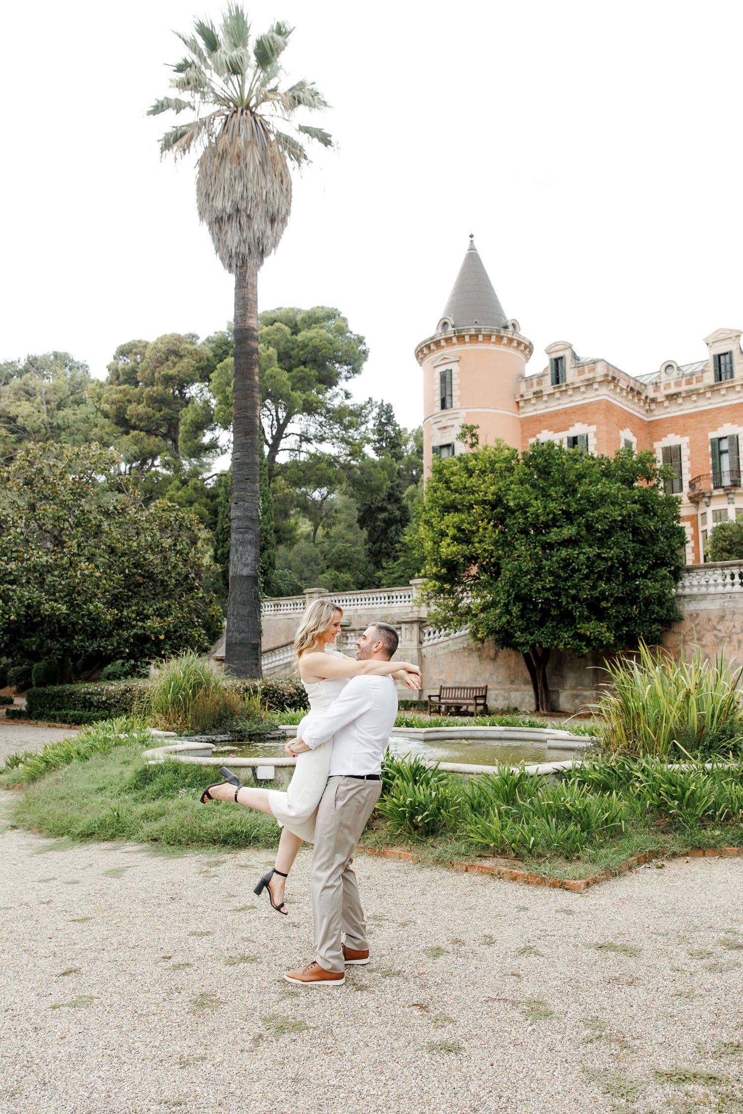 The groom lifts the bride and spins her as they exchange laughter and smiles.