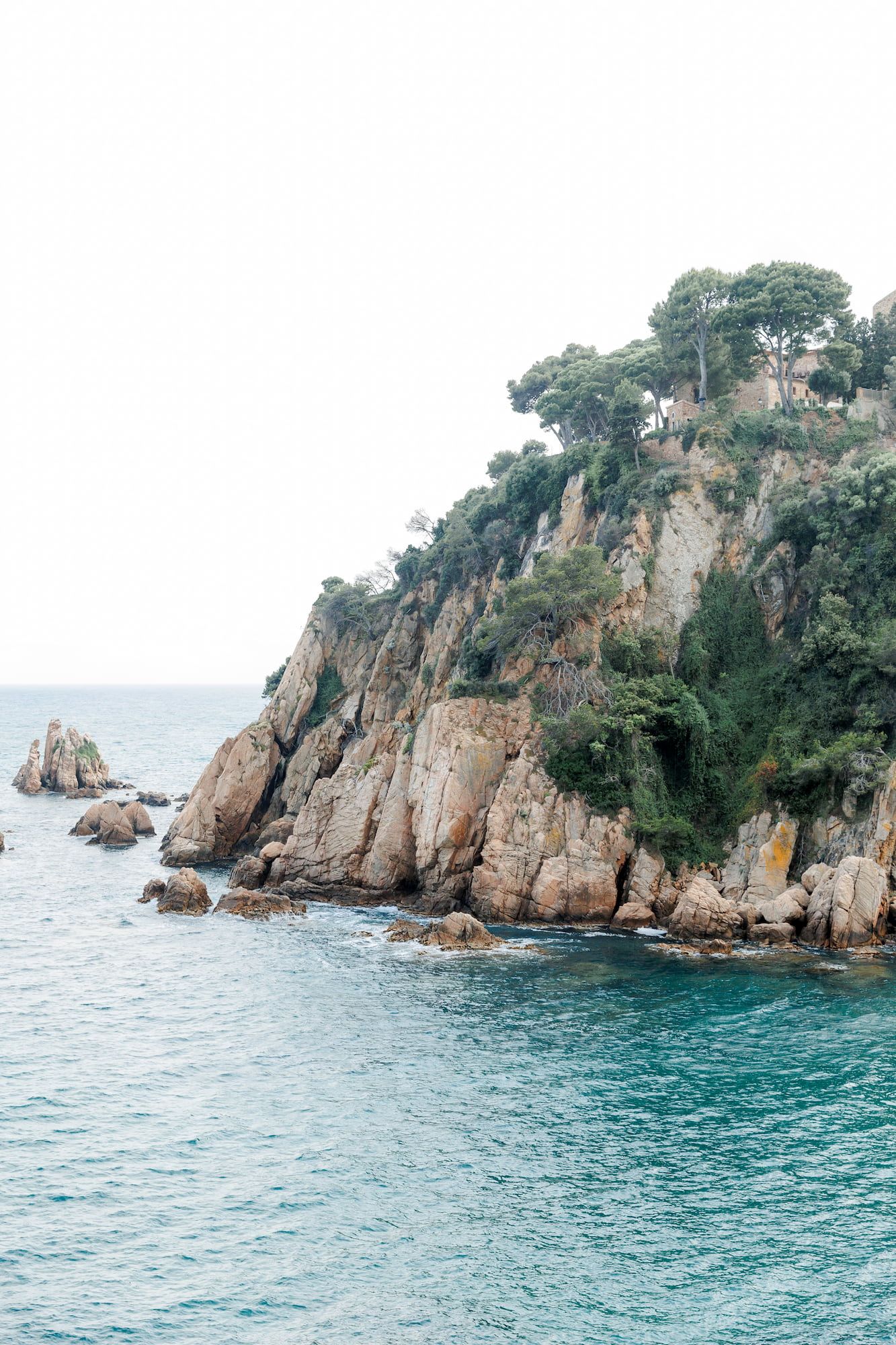 Rugged coastal cliffs with turquoise Mediterranean waters and rocky outcrops along a scenic shoreline.