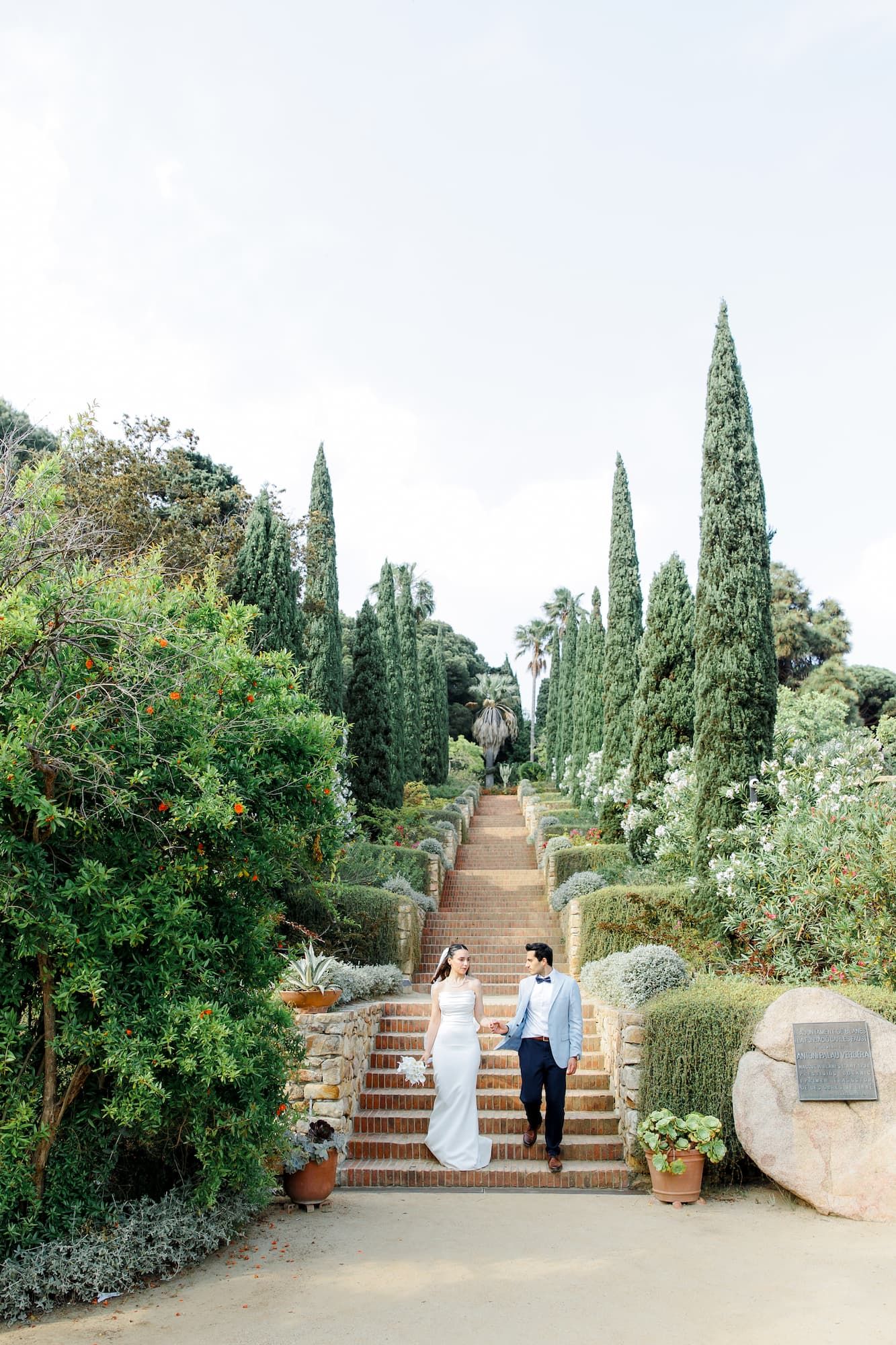 A couple walking down the stairs of Marimurtra Botanical Garden for exchanging the vows