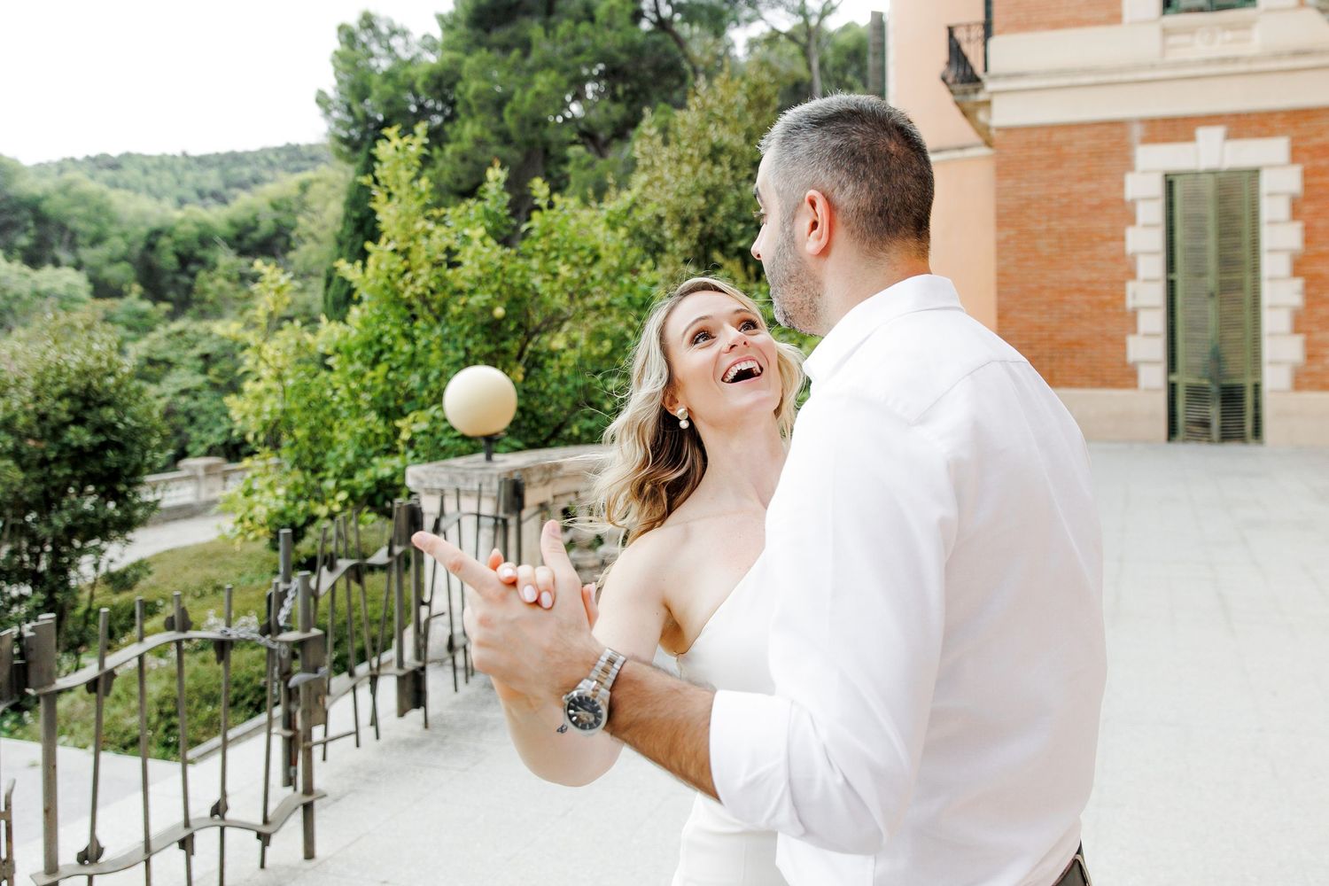 A woman in a white dress dances with a man in a white shirt.