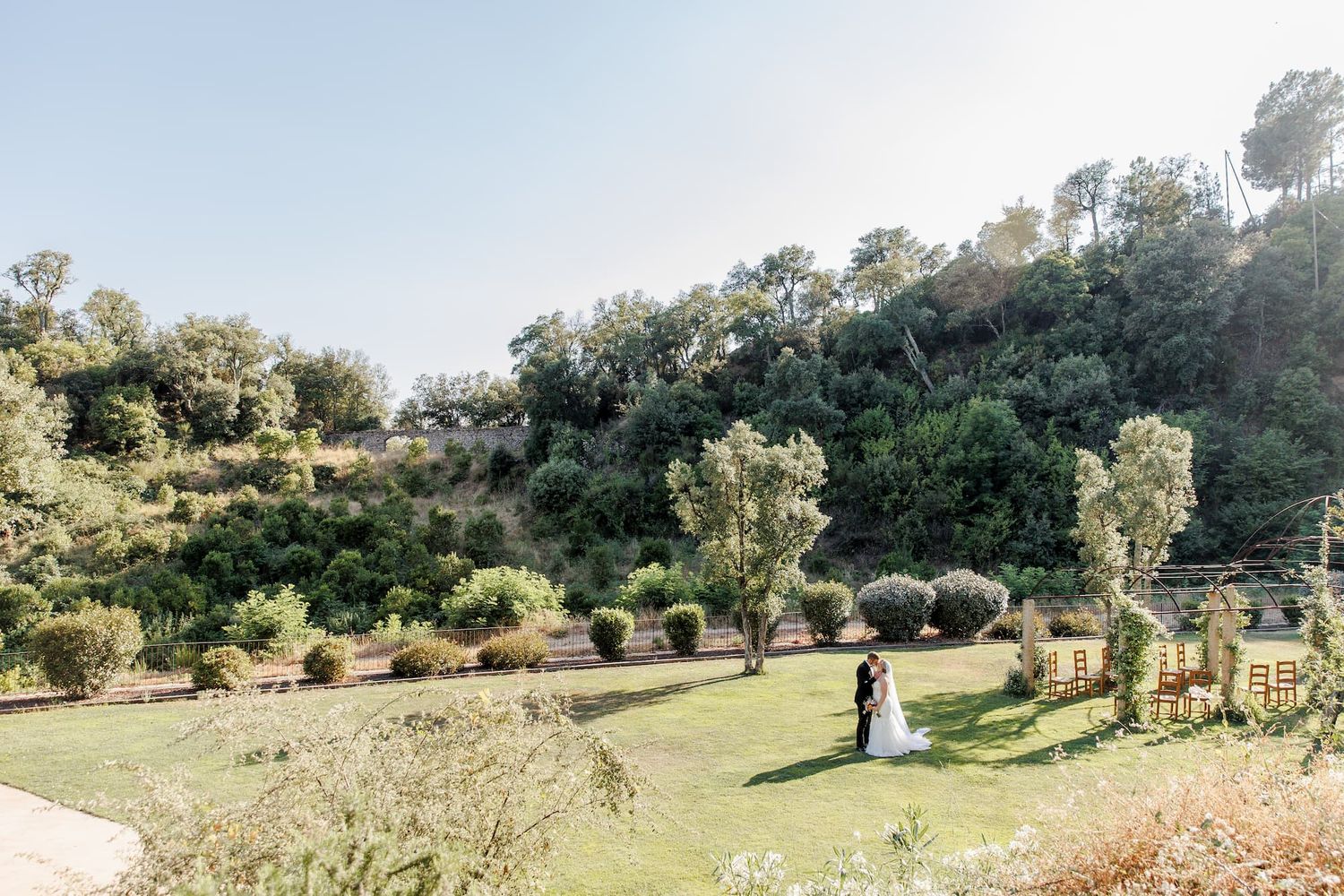 Rolling hills stretch out under the Mediterranean sun, dotted with trees.