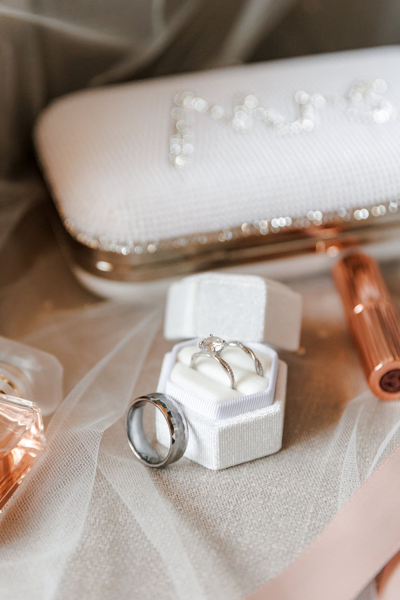 Wedding rings displayed in a white hexagonal box with a diamond engagement ring.