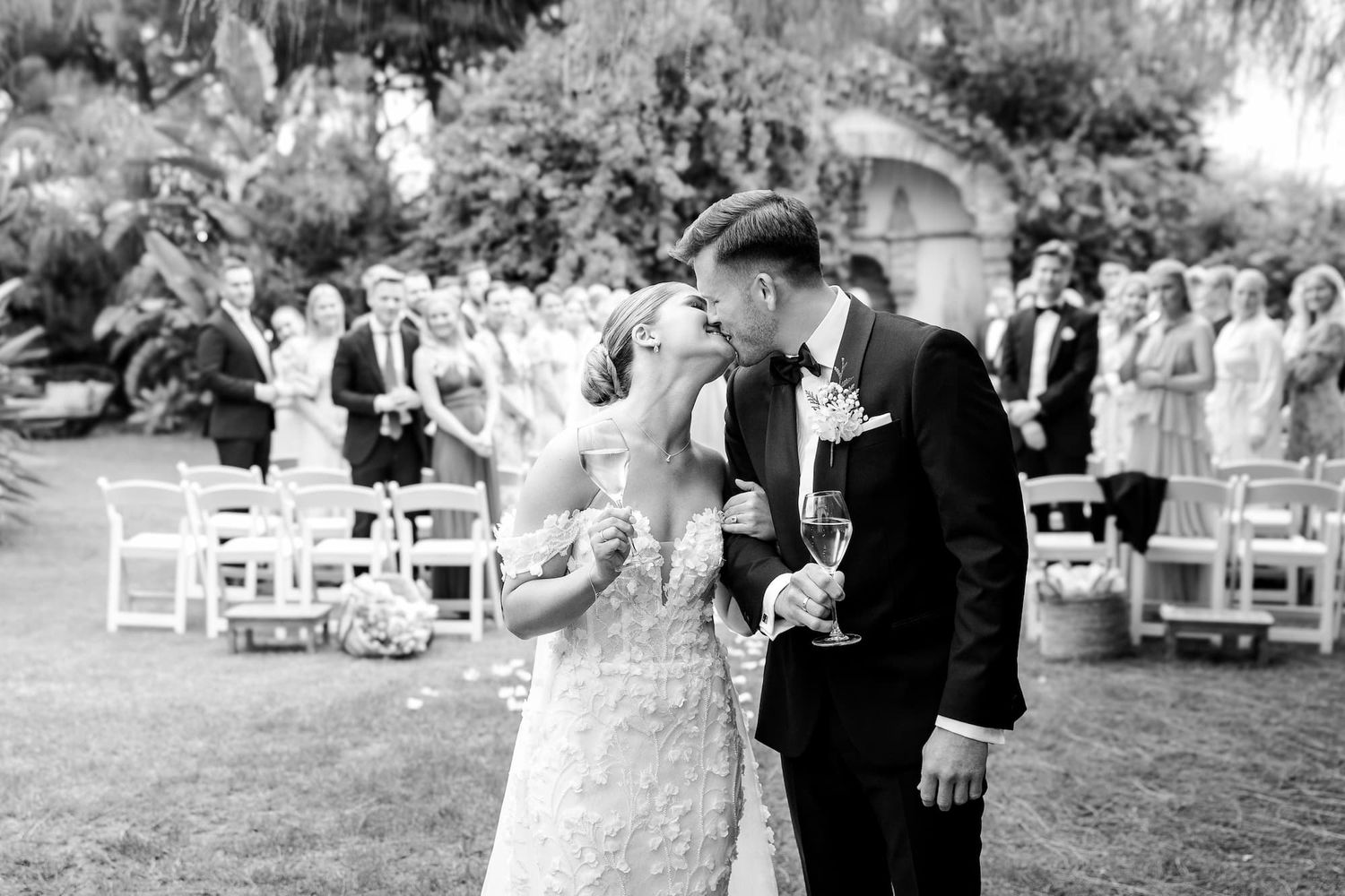 Black and white photo of bride and groom sharing a kiss after wedding ceremony near Barcelona