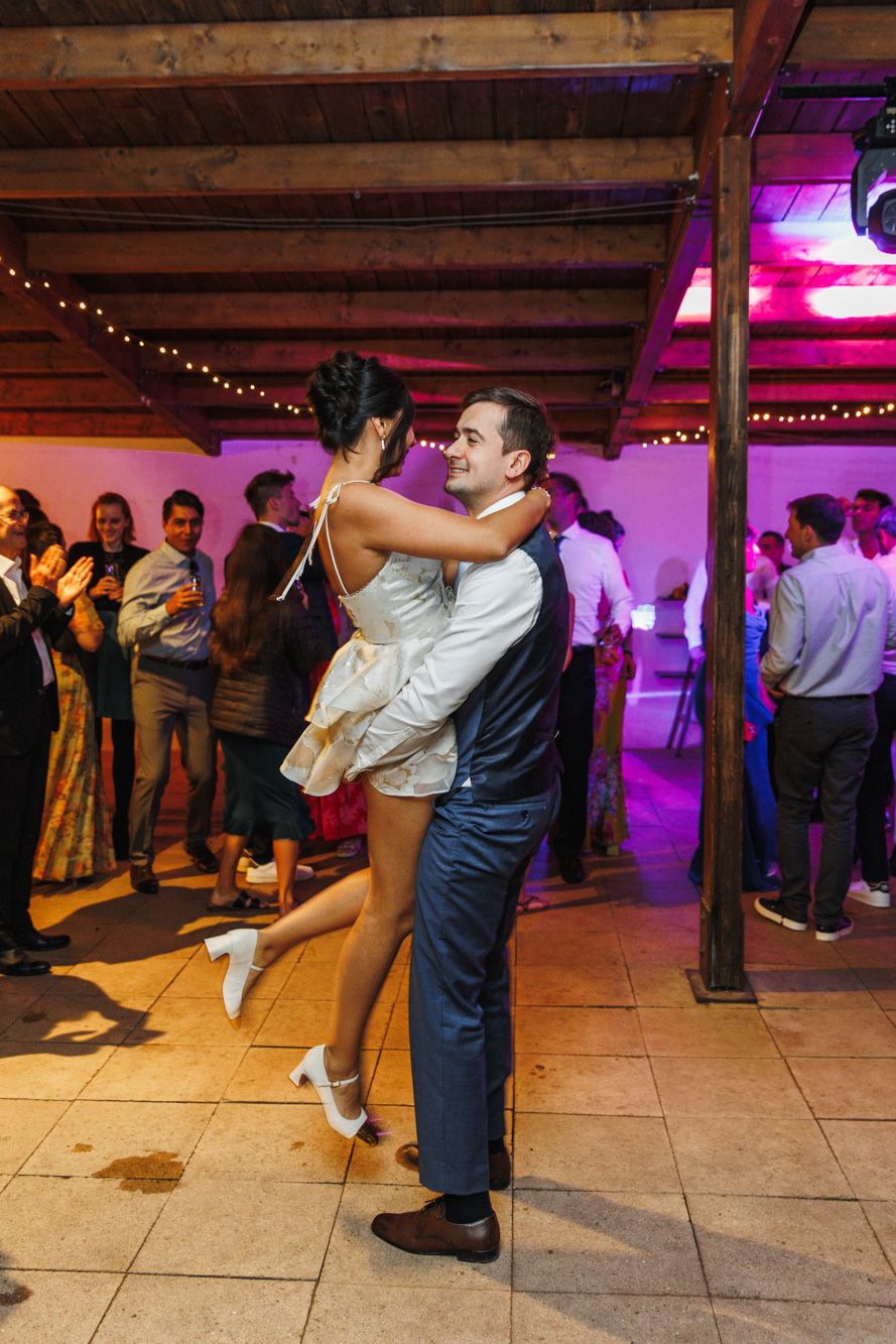 Groom lifting bride during first dance at wedding reception at La Baronia near Barcelona